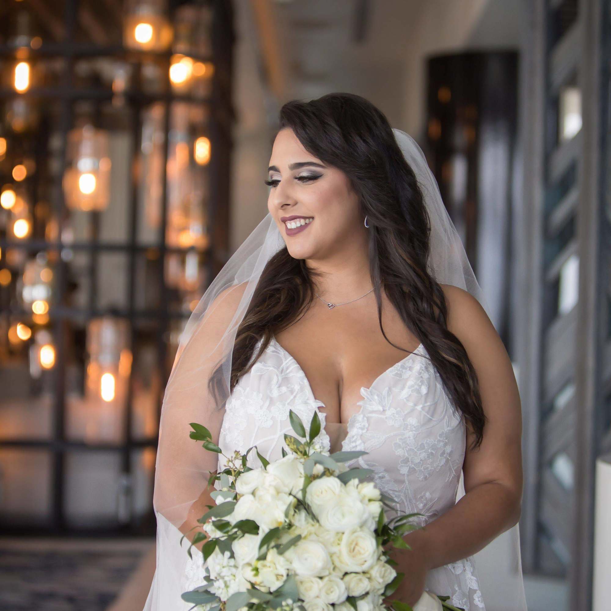 Bride holding a white rose bouquet with greenery