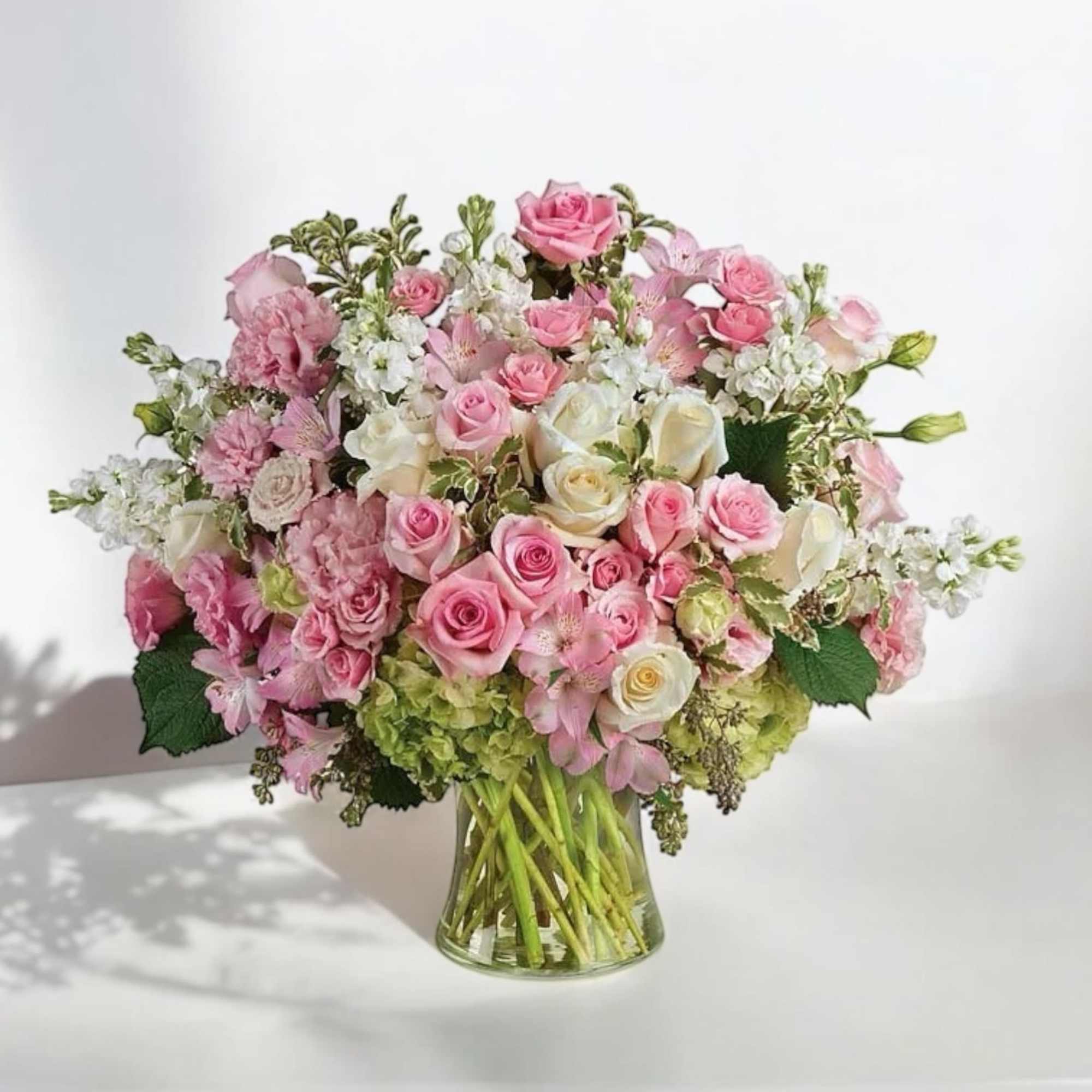 Pink and white rose bouquet in a clear glass vase