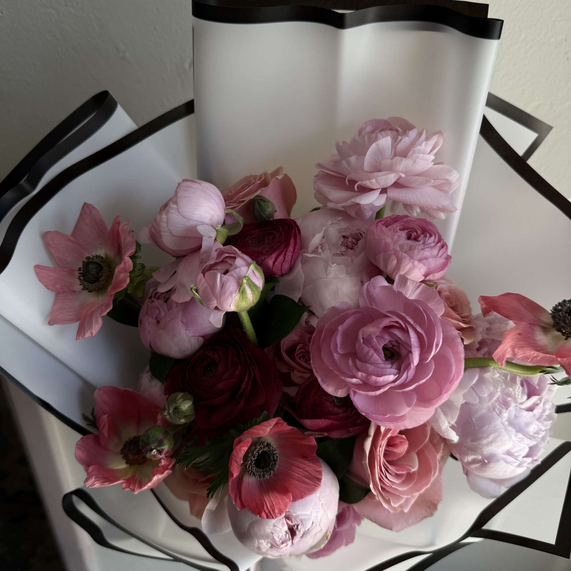A garden-inspired bouquet featuring lush peonies, ranunculus, roses and anemones, arranged to, photo 2 of 2
