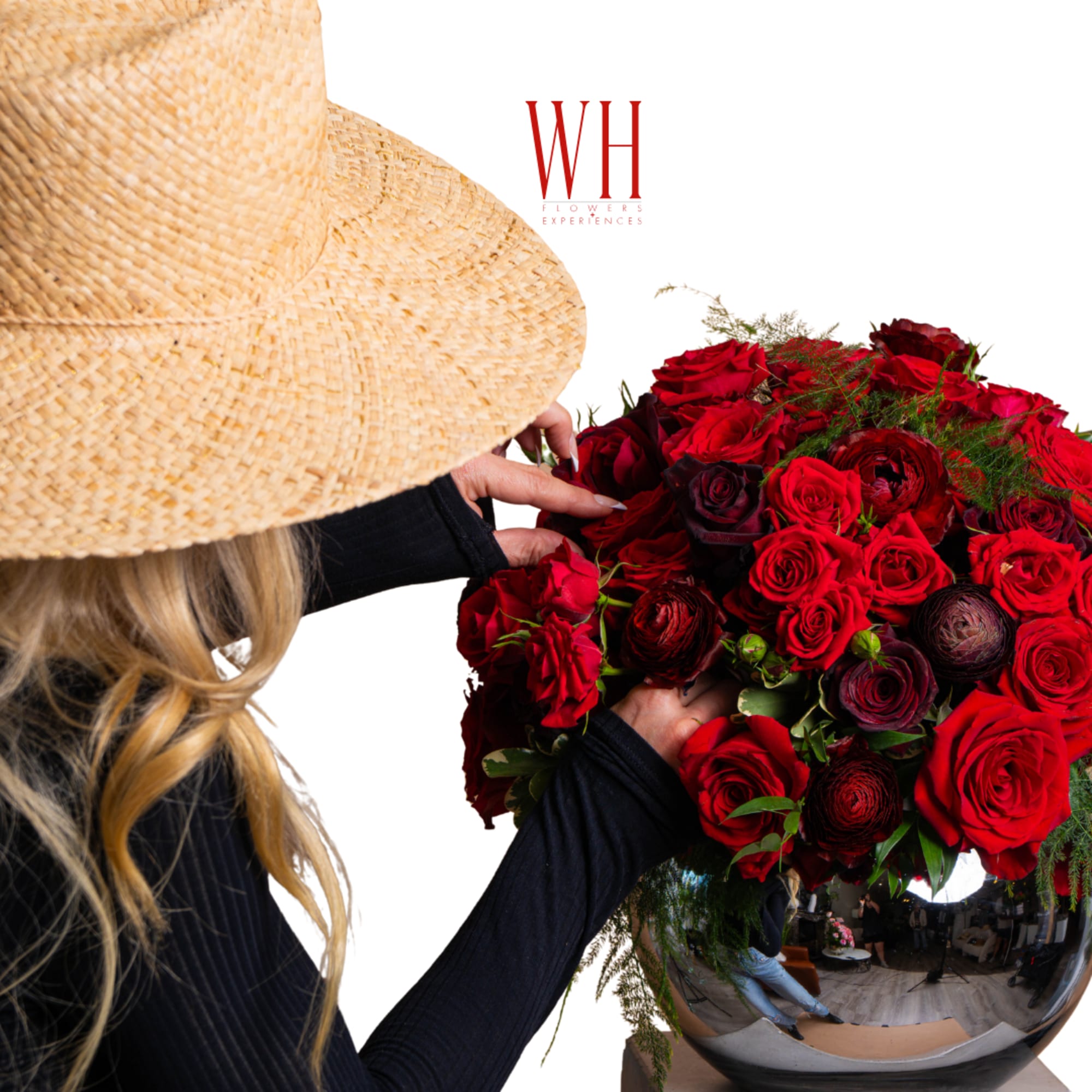 Woman arranging a bouquet of red roses in a reflective vase