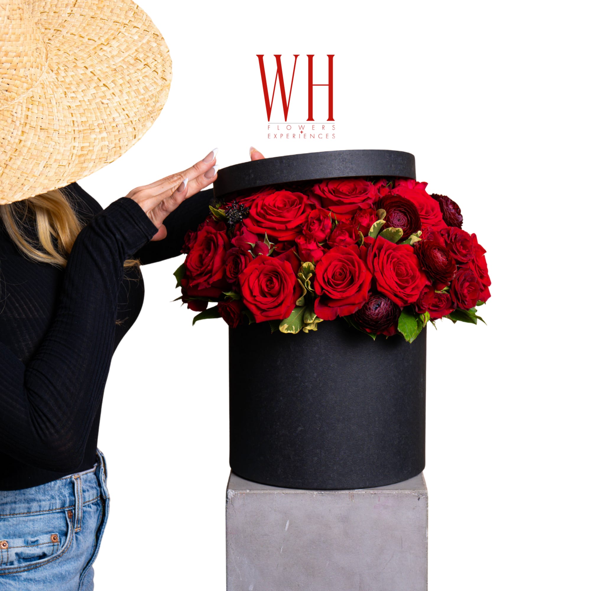 Red roses arranged in a black hat box