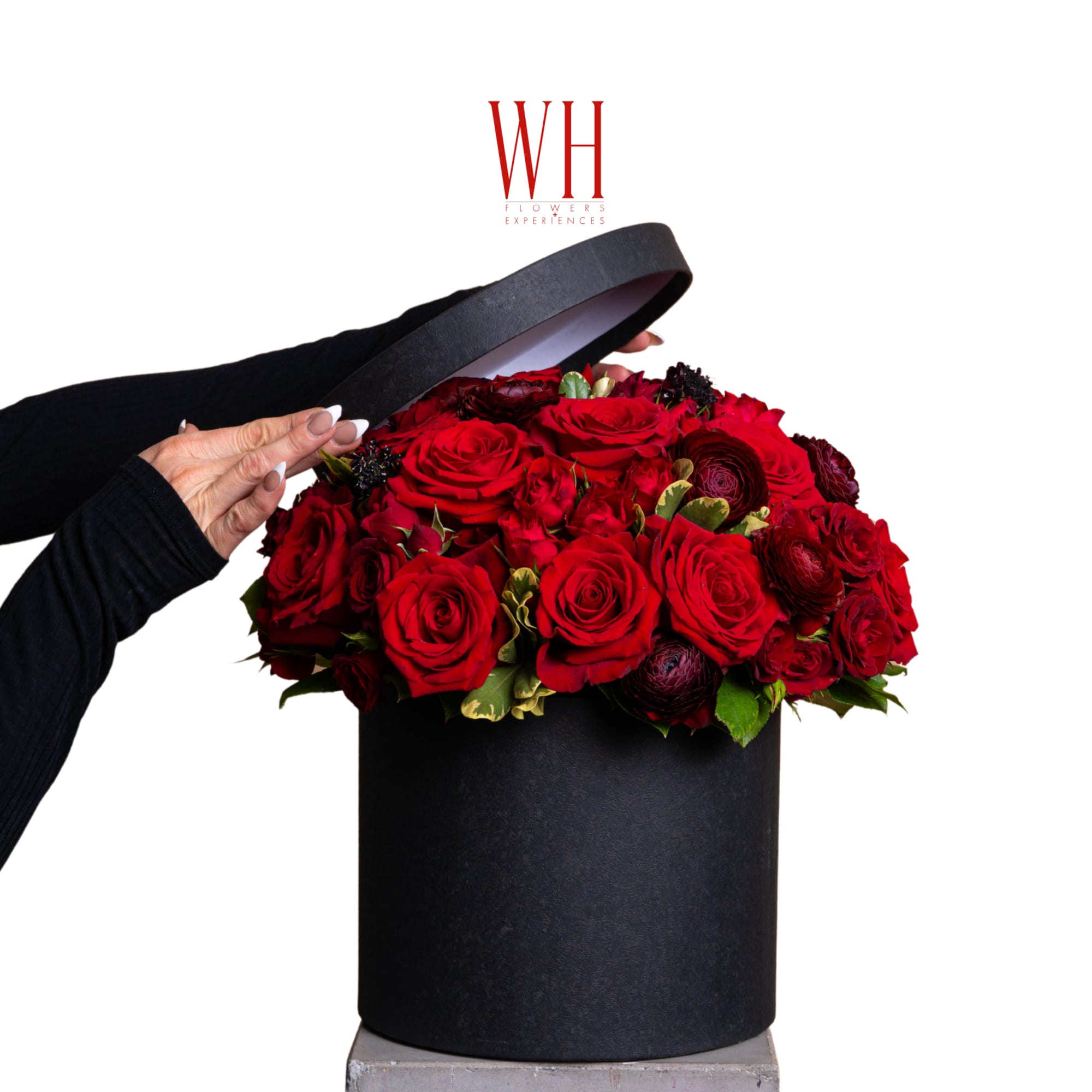 Red roses arranged in a black round hat box