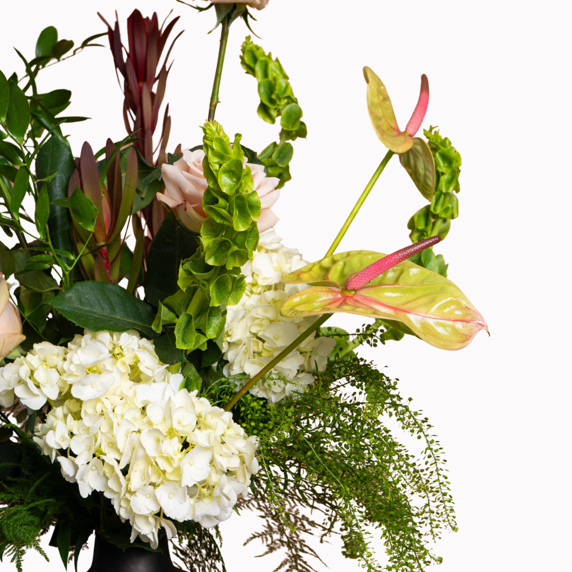Arrangement with white hydrangeas, pale roses, and pink anthuriums