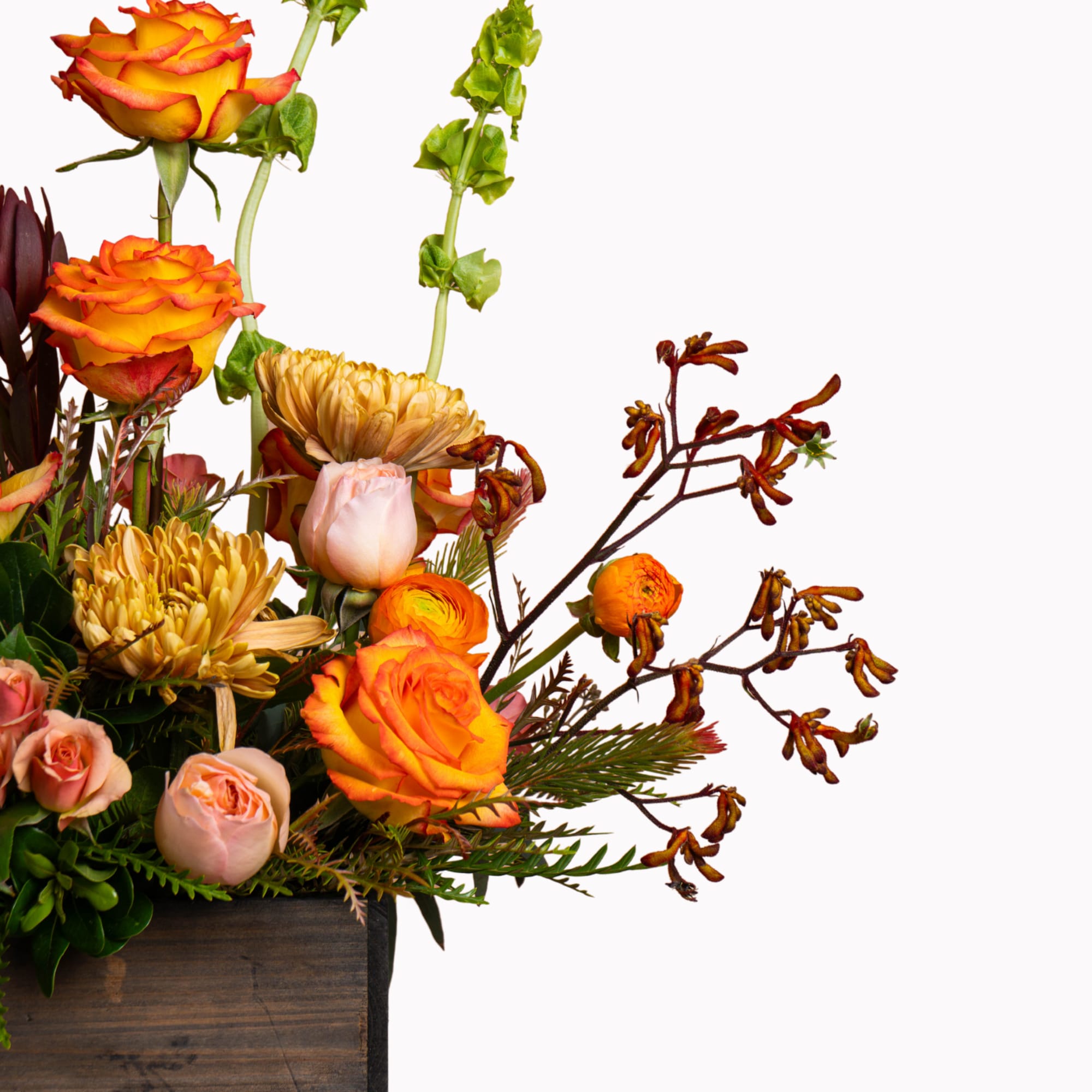 Orange roses and pale blooms in a wooden box arrangement