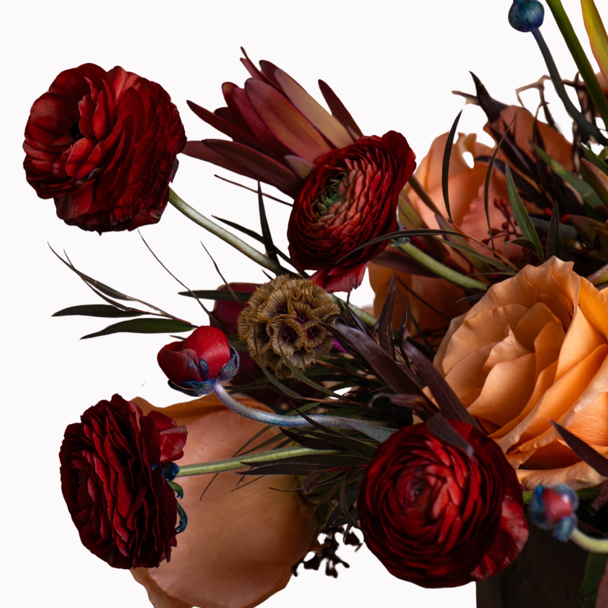 Bouquet of deep red and peach flowers with dark foliage