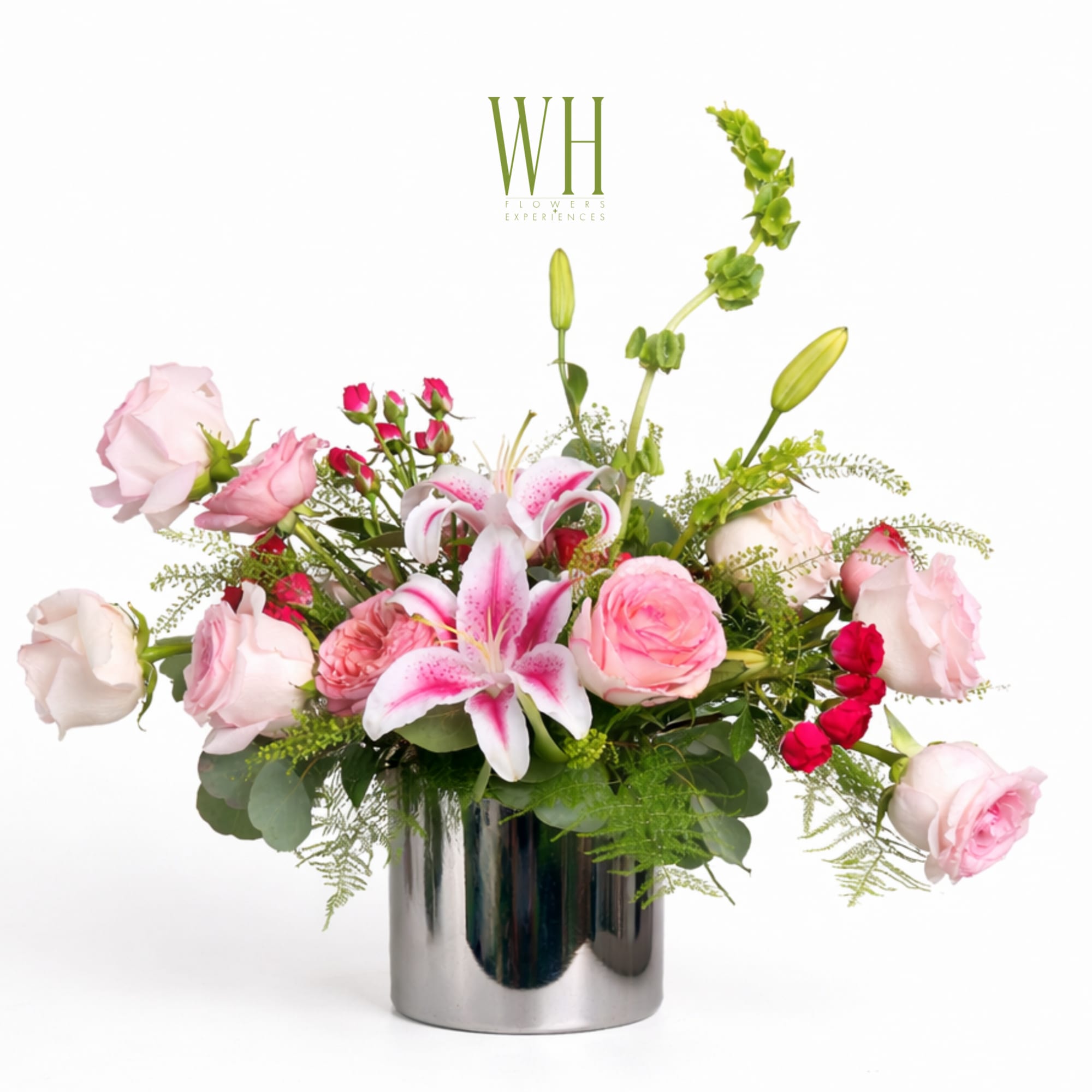 Pink roses and lilies arranged in a silver vase