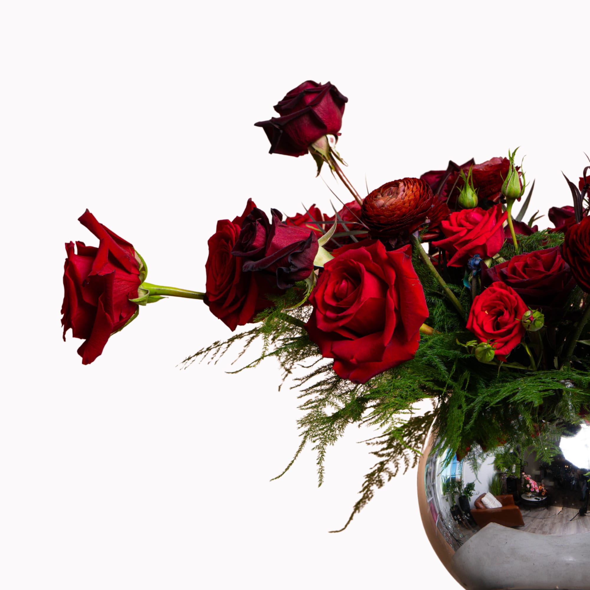 Red roses arranged in a reflective silver vase