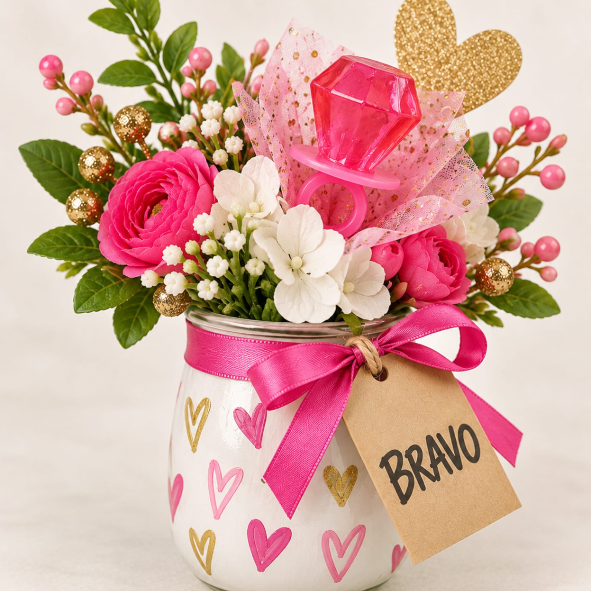 Pink and white flowers in a decorated glass jar with a Bravo tag