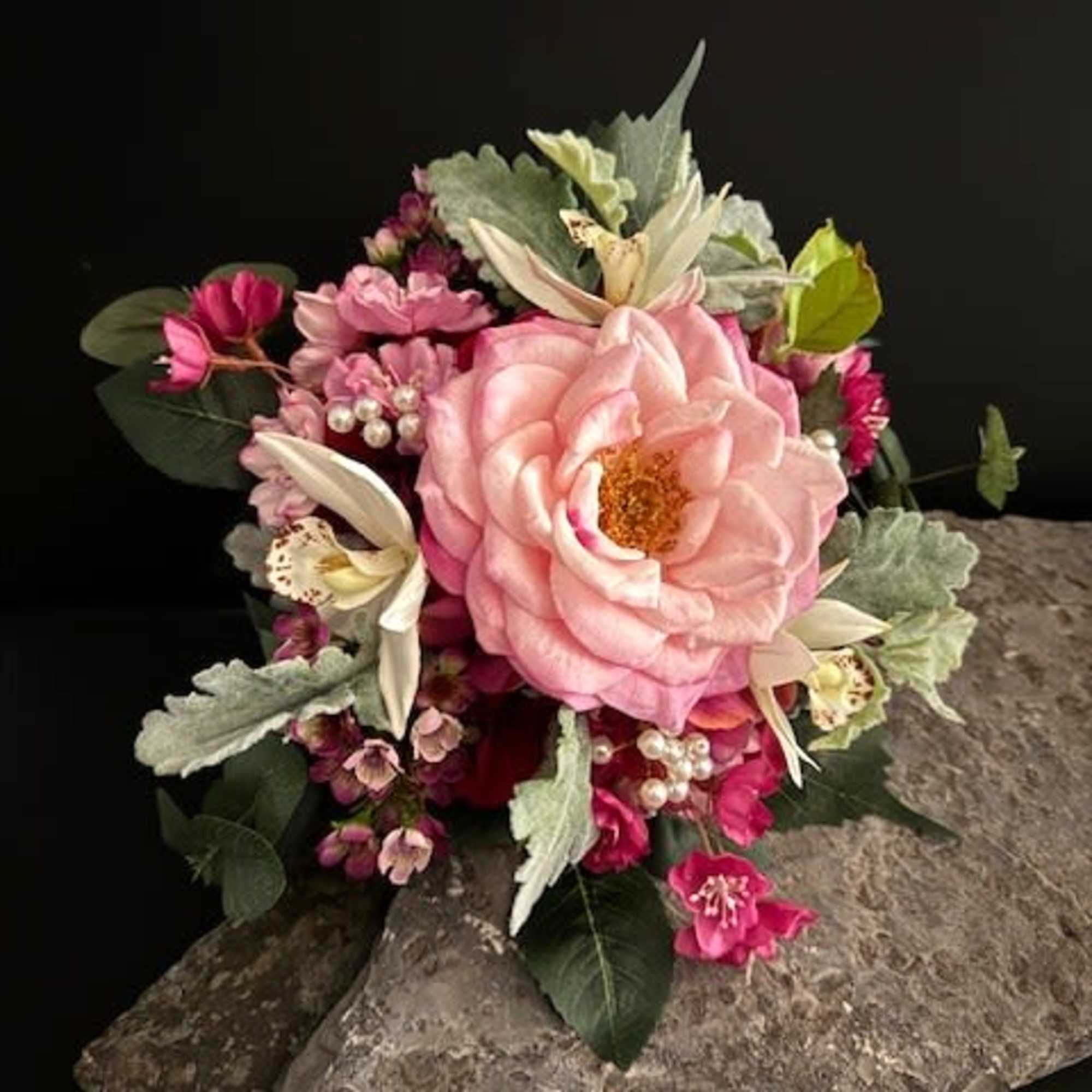 A lush, hand-held fuchsia hydrangea-style bouquet centered on a single large pink