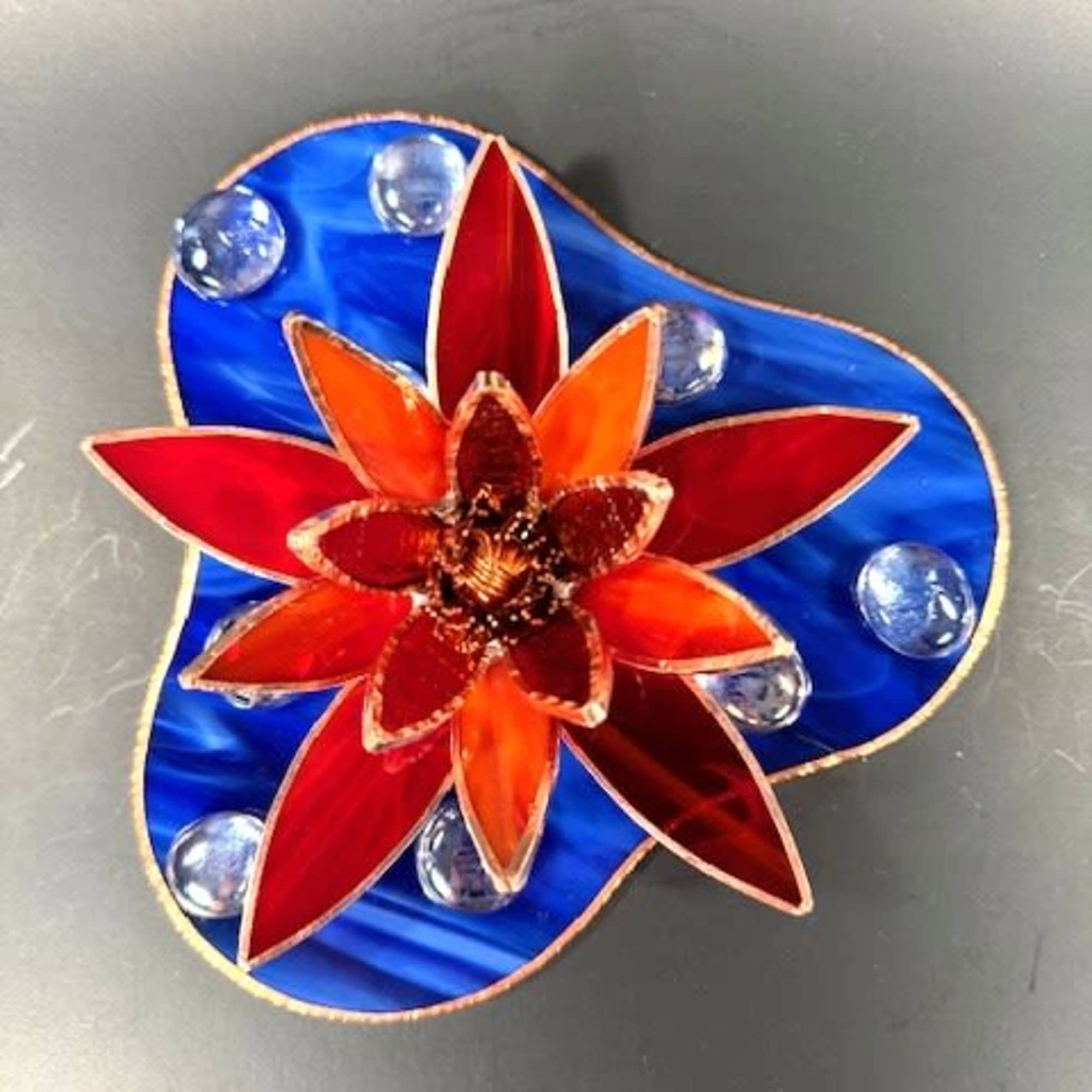 A bold red and orange stained-glass water lily mounted on a marbled, photo 2 of 2