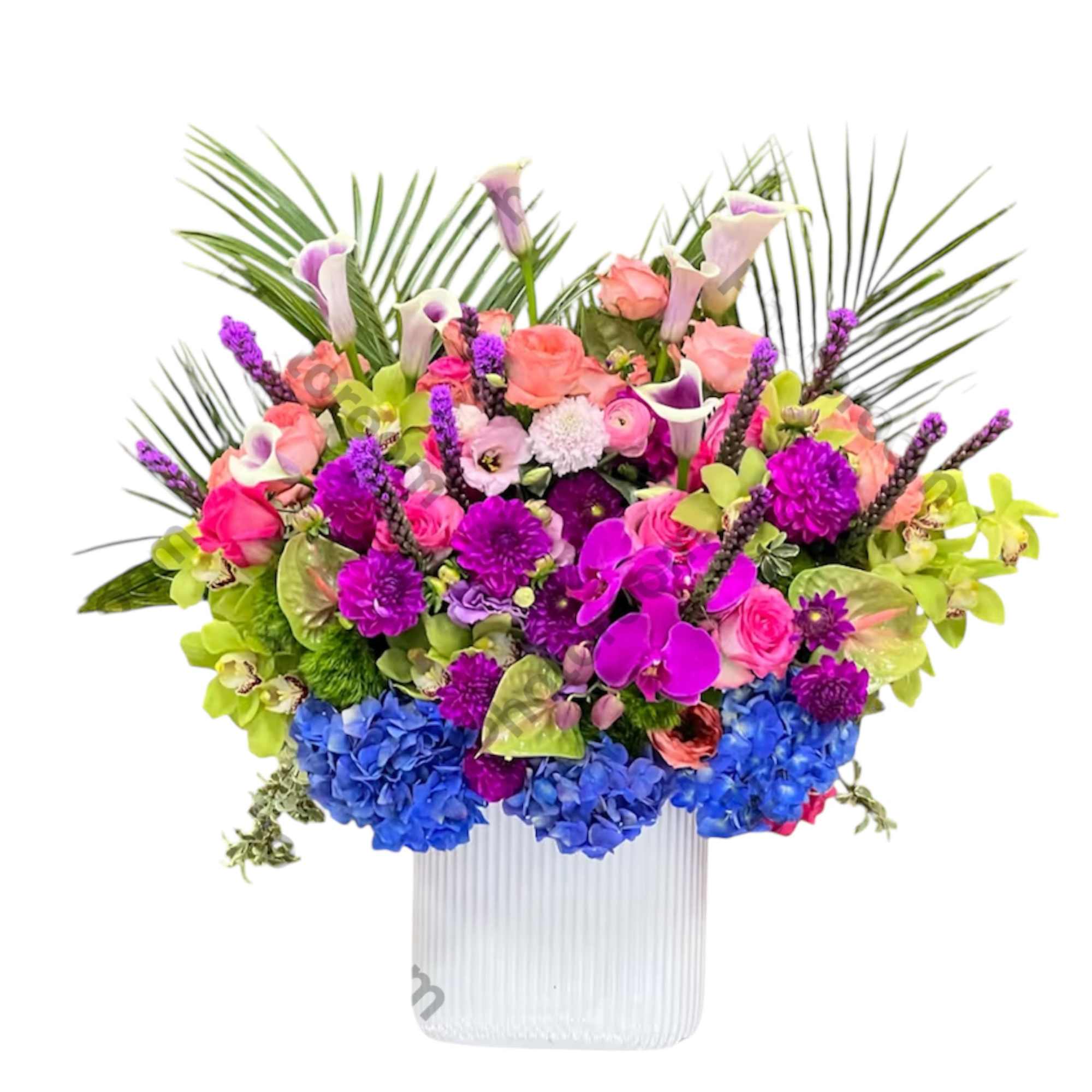 Bright mixed bouquet in a ribbed white vase with pink, purple, blue, and green flowers