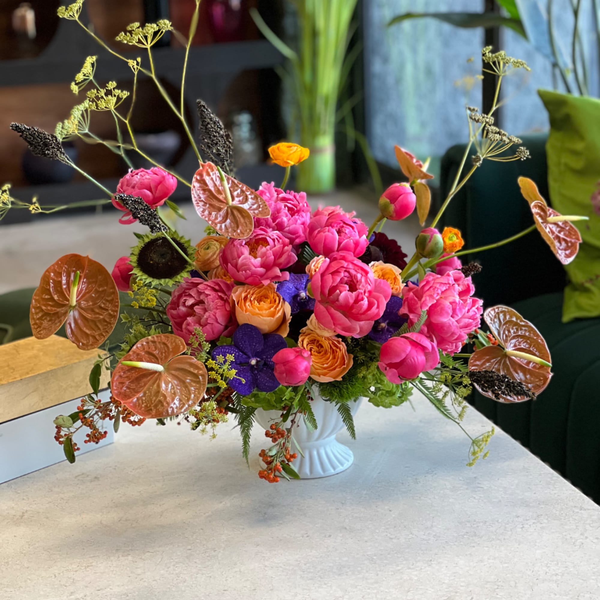 Bright mixed bouquet in a white vase with pink, orange, and purple blooms