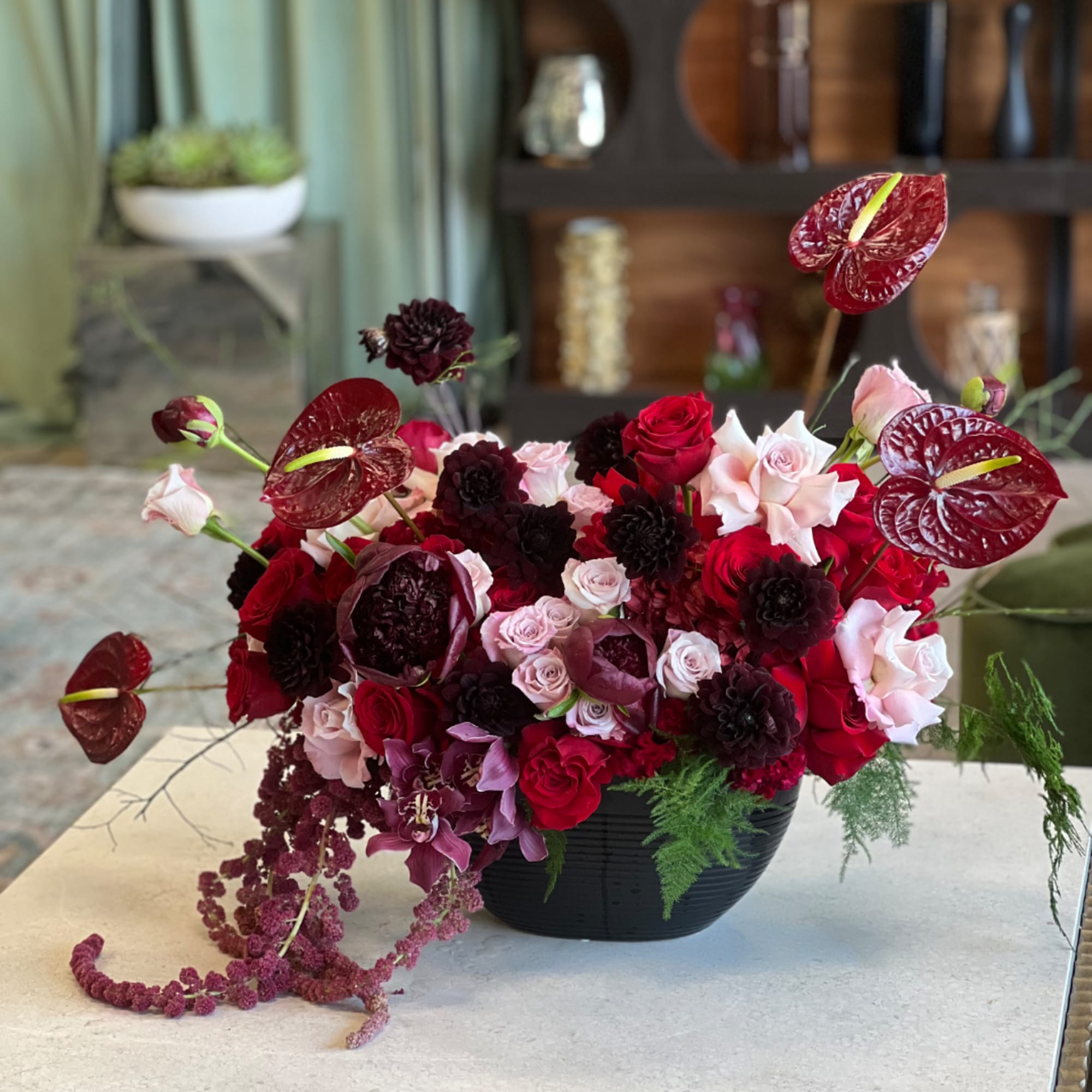 Red and pink floral arrangement in a black bowl vase, photo 2 of 2