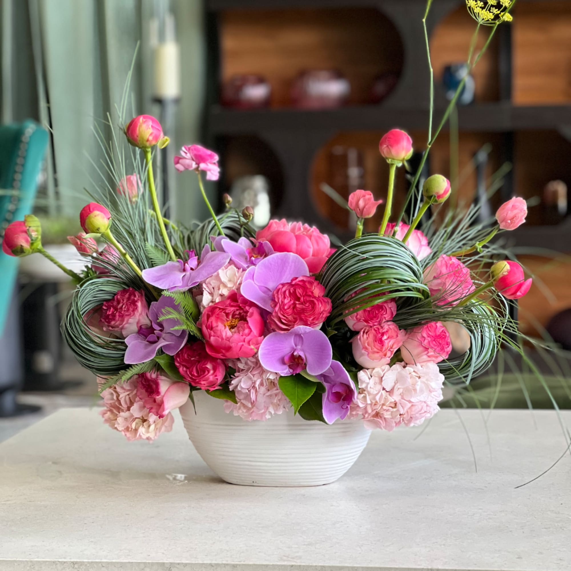 Pink and lavender floral arrangement in a white bowl vase