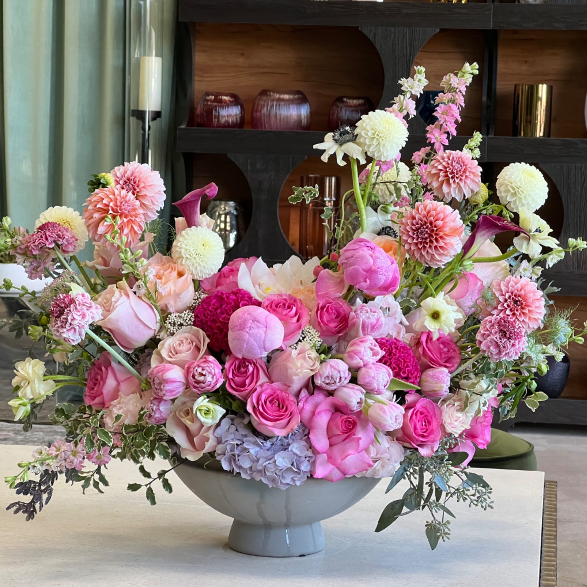 Large pink and white floral arrangement in a gray bowl vase