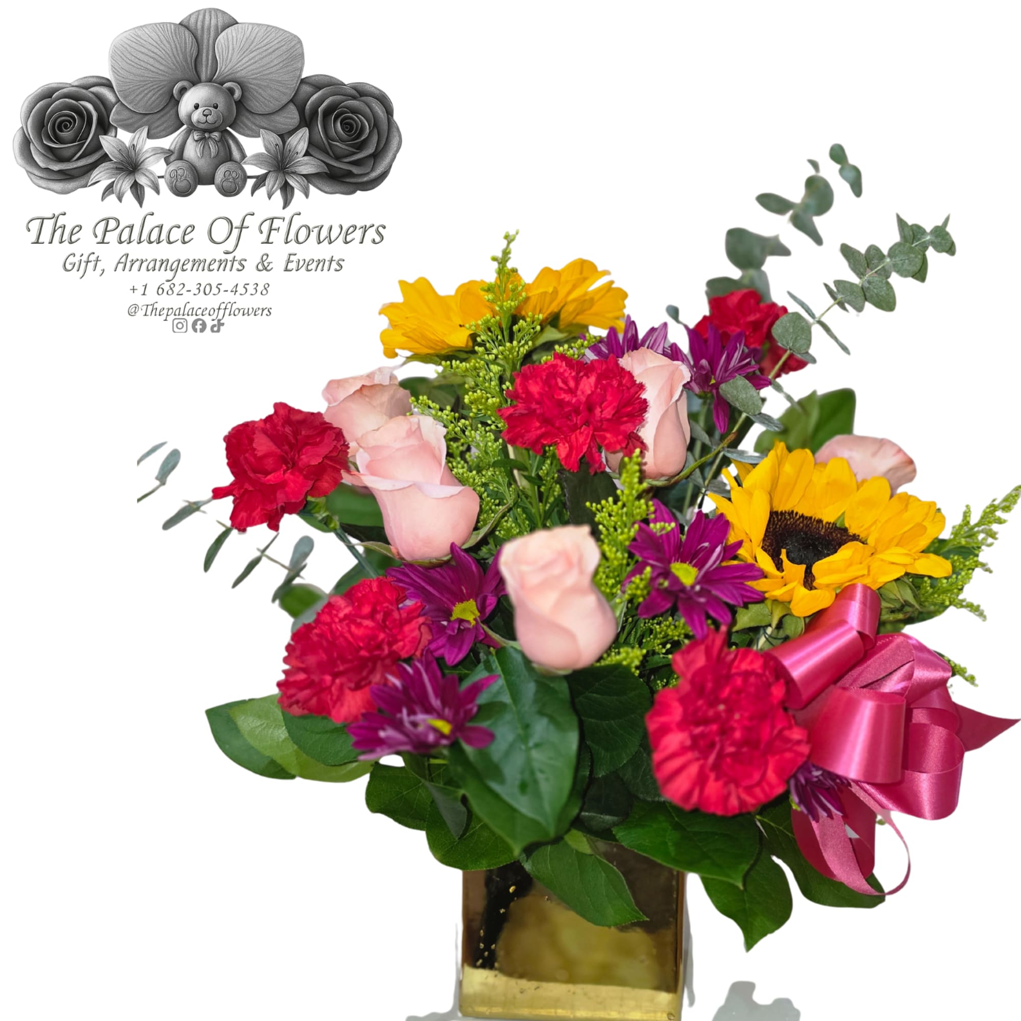 Mixed bouquet with roses, carnations, sunflowers, and purple daisies in a gold vase