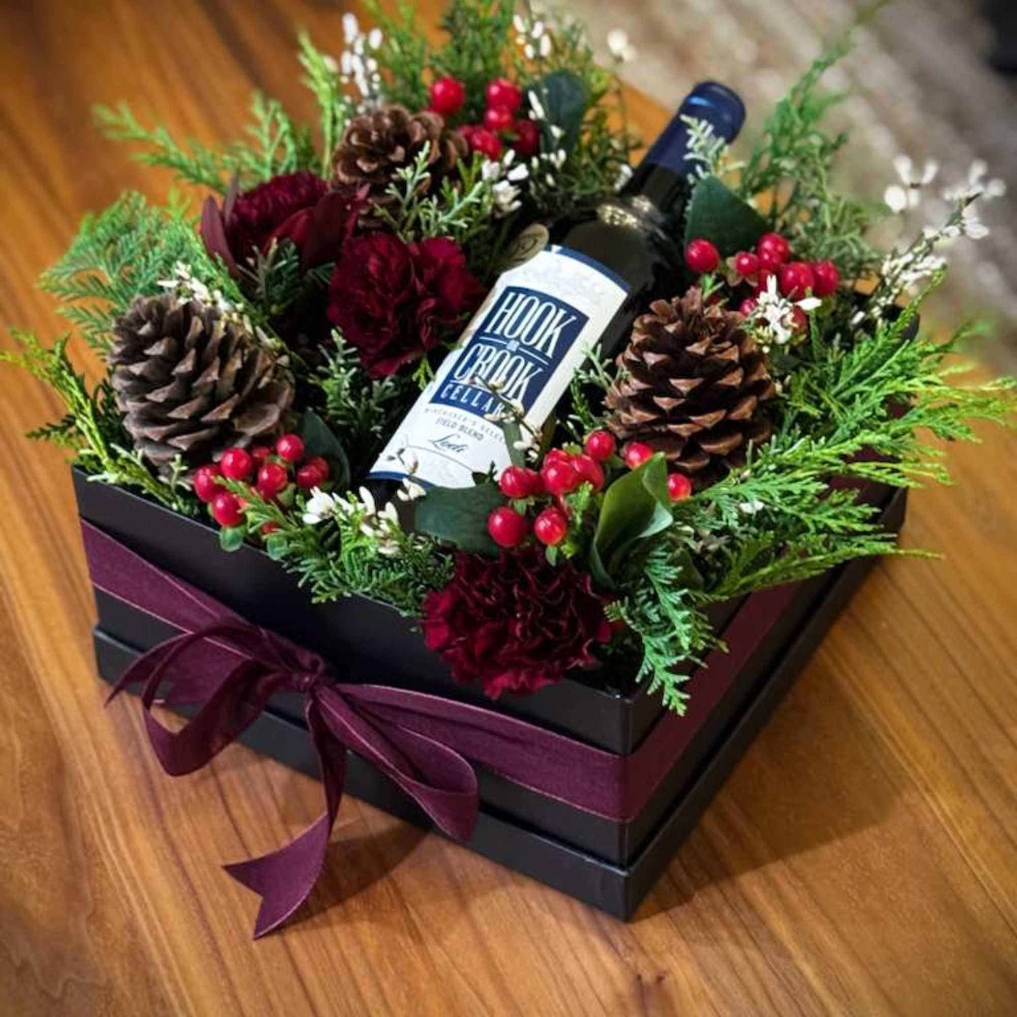 Our Holiday Wine Box Floral Arrangement is a limited-edition design created to