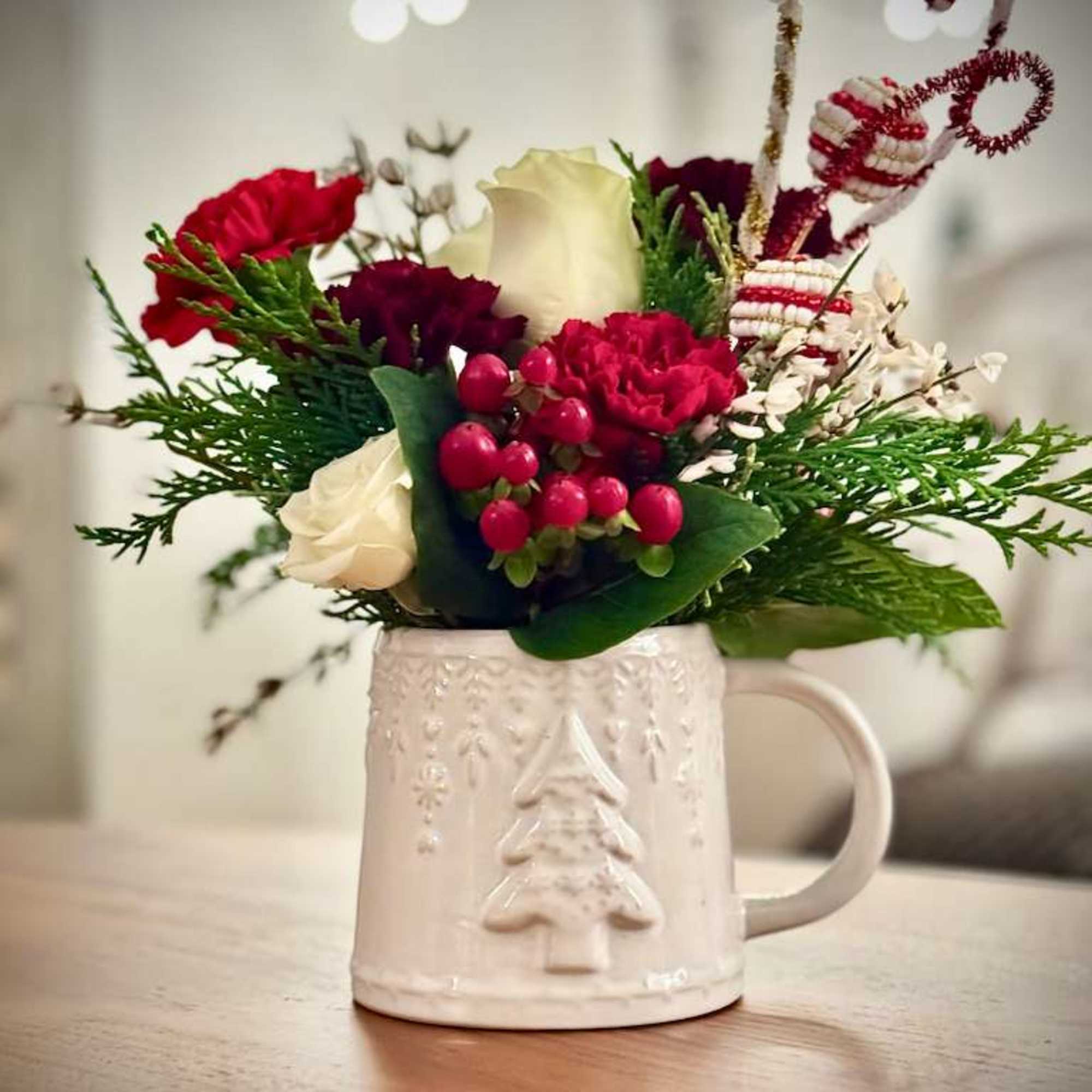 Our Christmas Mug Floral Arrangement is a charming seasonal design created in