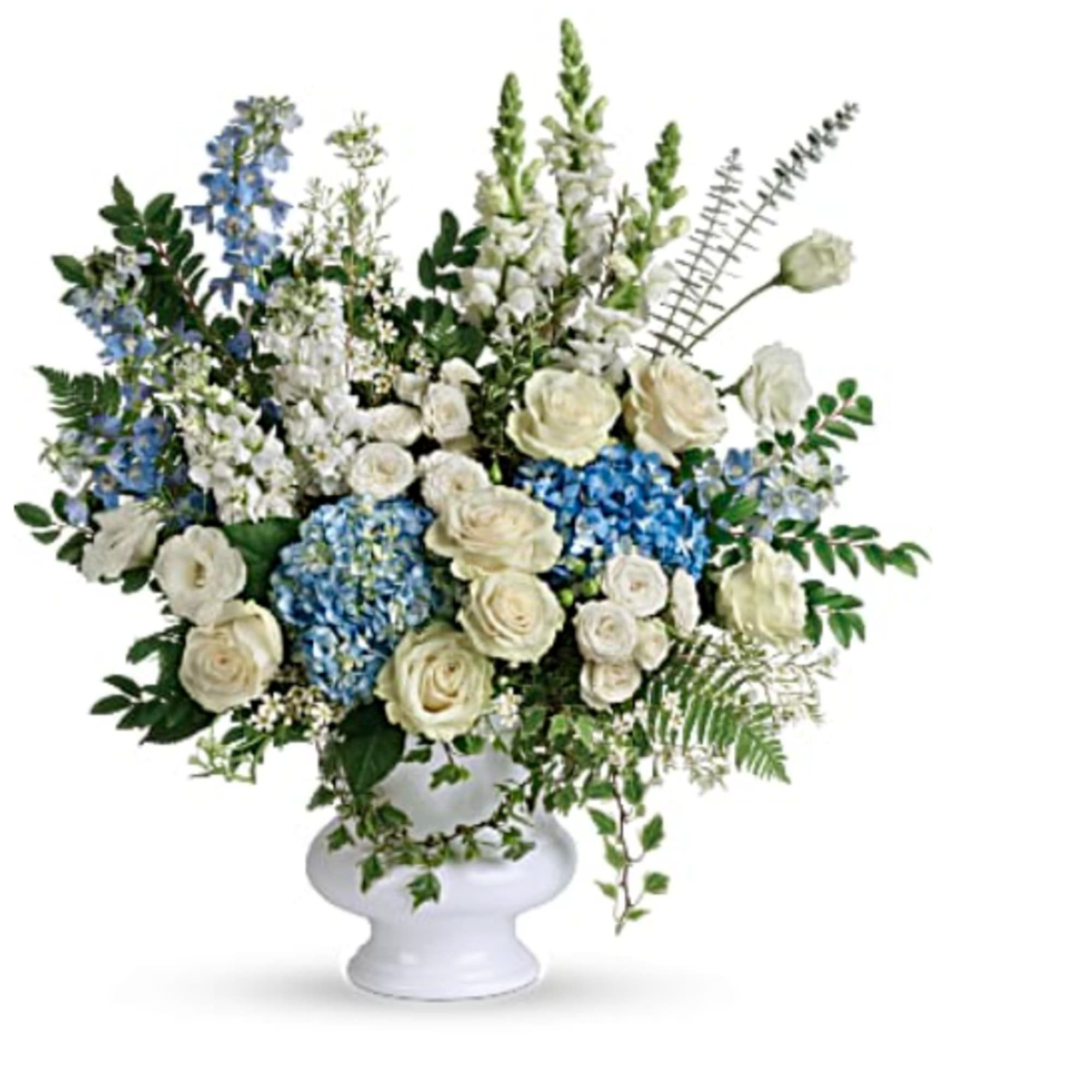 White and blue floral arrangement in a white pedestal vase