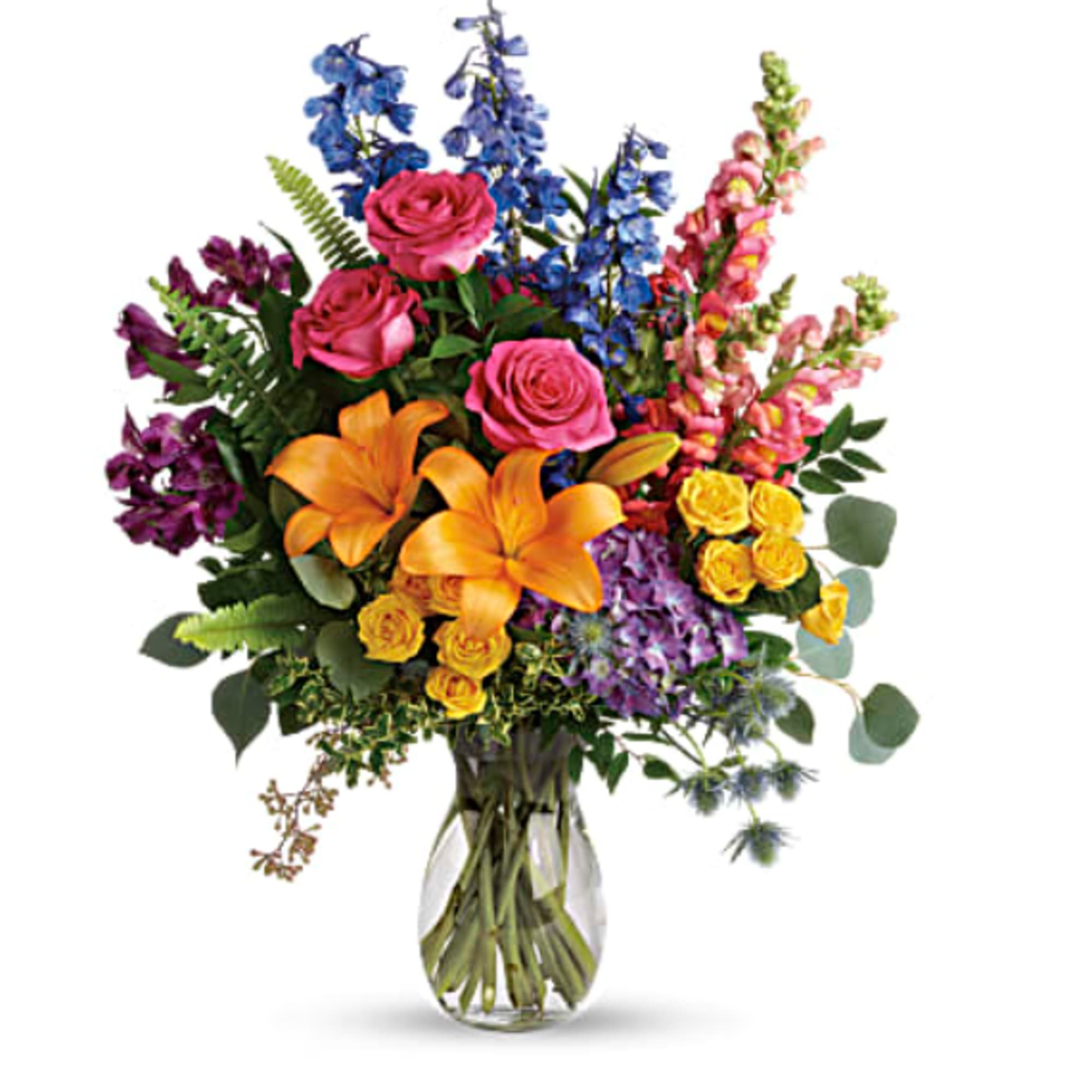 Colorful bouquet of roses, lilies, and tall blue flowers in a glass vase