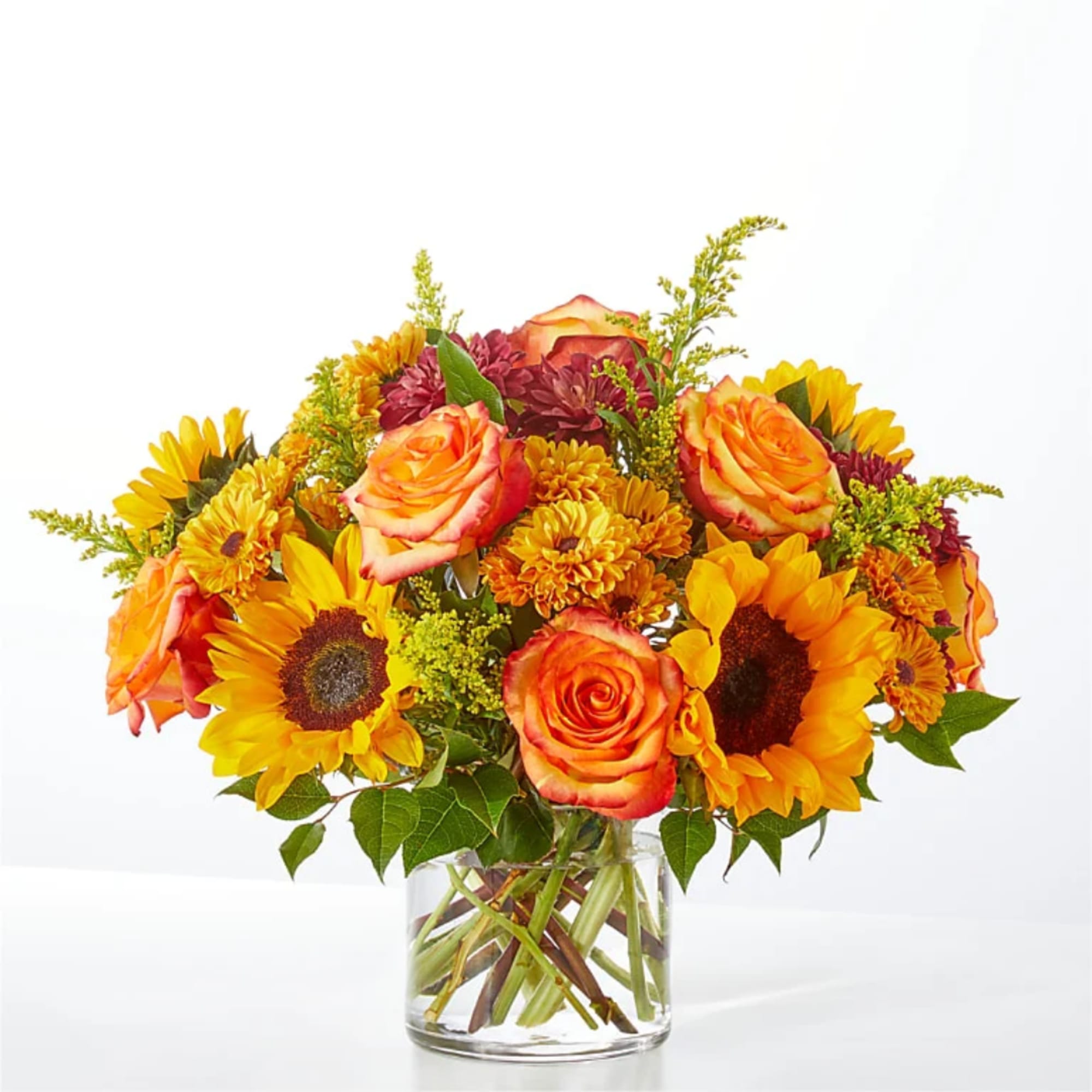Bouquet of orange roses and yellow sunflowers in a clear glass vase