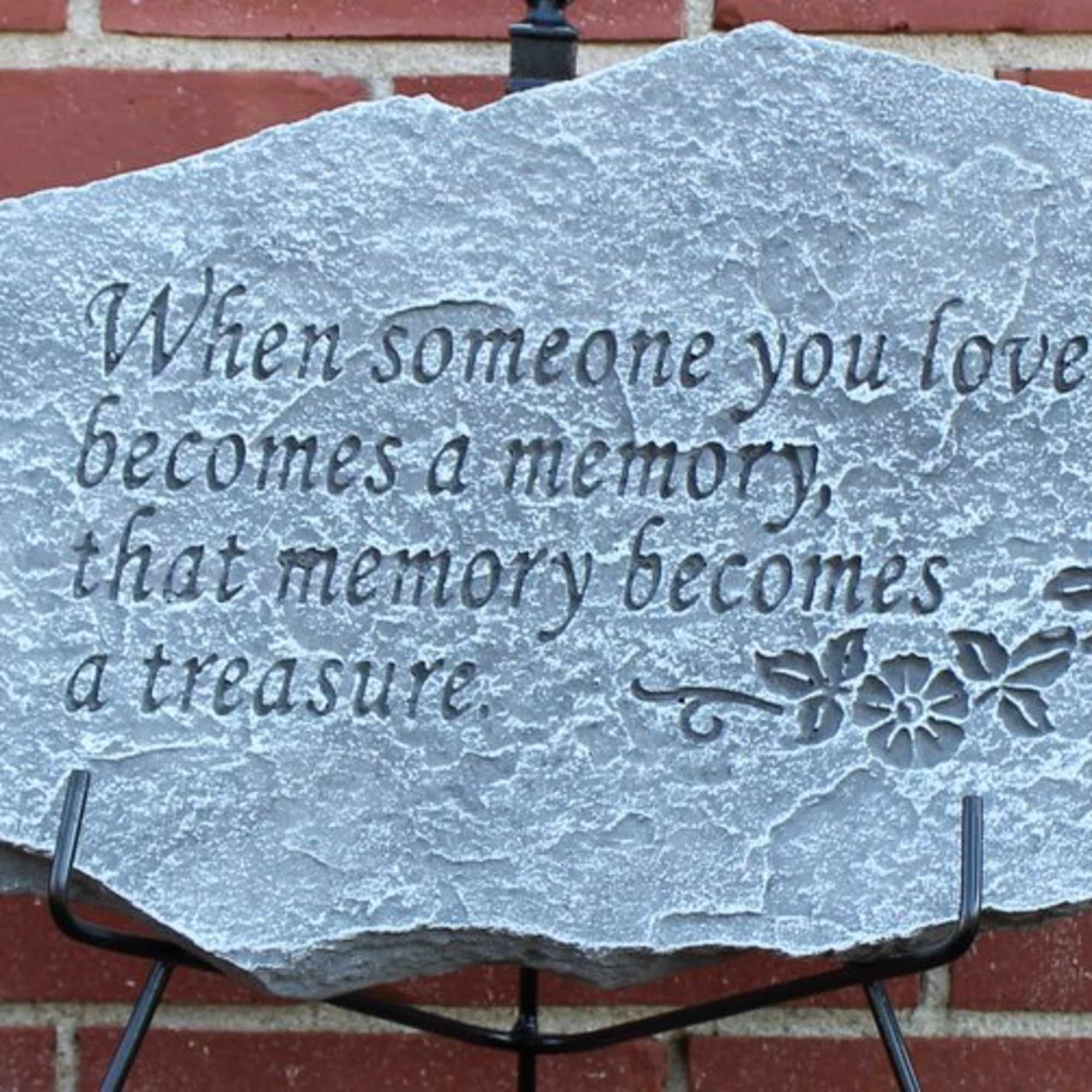 Engraved memorial stone with a sympathy quote on a stand