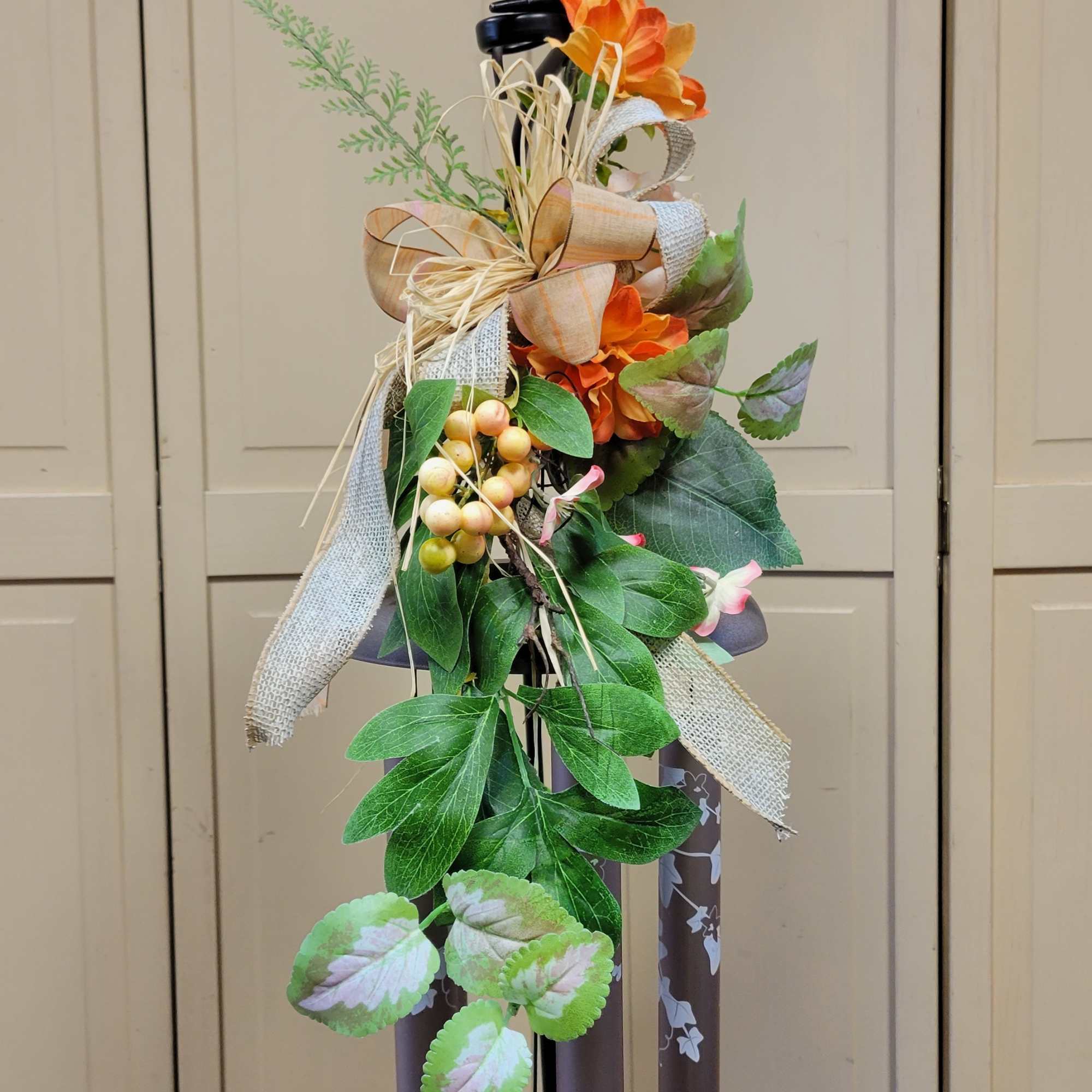 Memorial wind chime with orange flowers and greenery