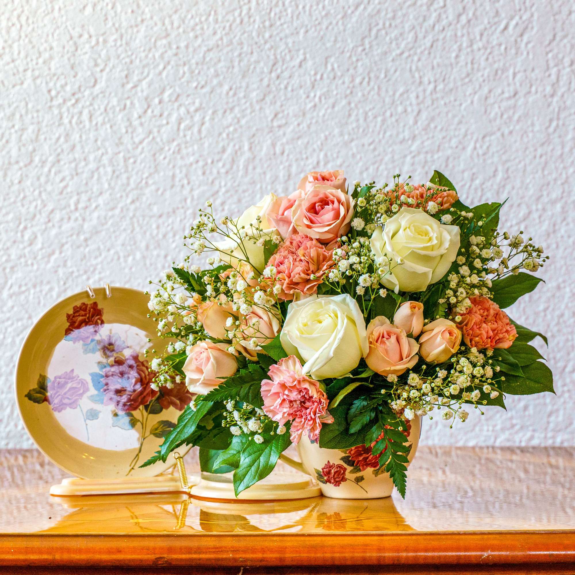This charming teacup of roses, carnations, and baby's breath is sure to