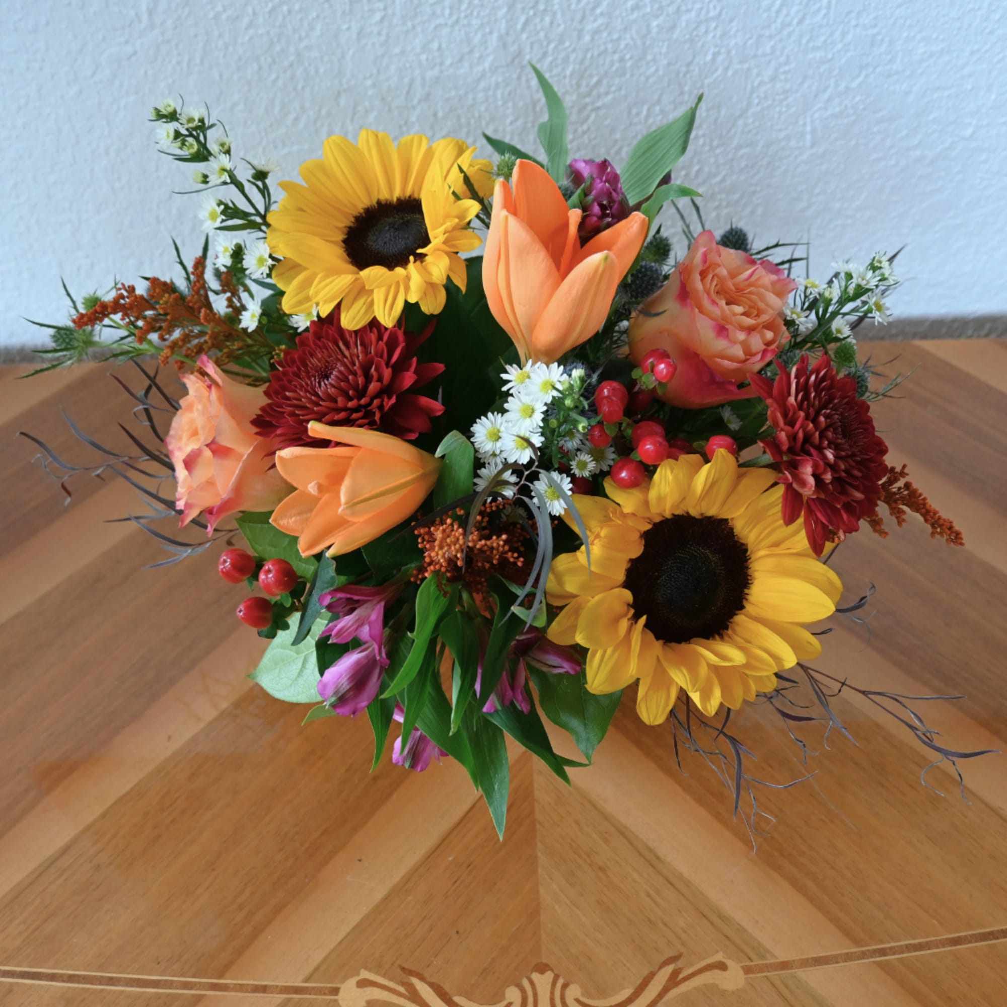 Mixed bouquet with sunflowers, orange tulips, and peach roses
