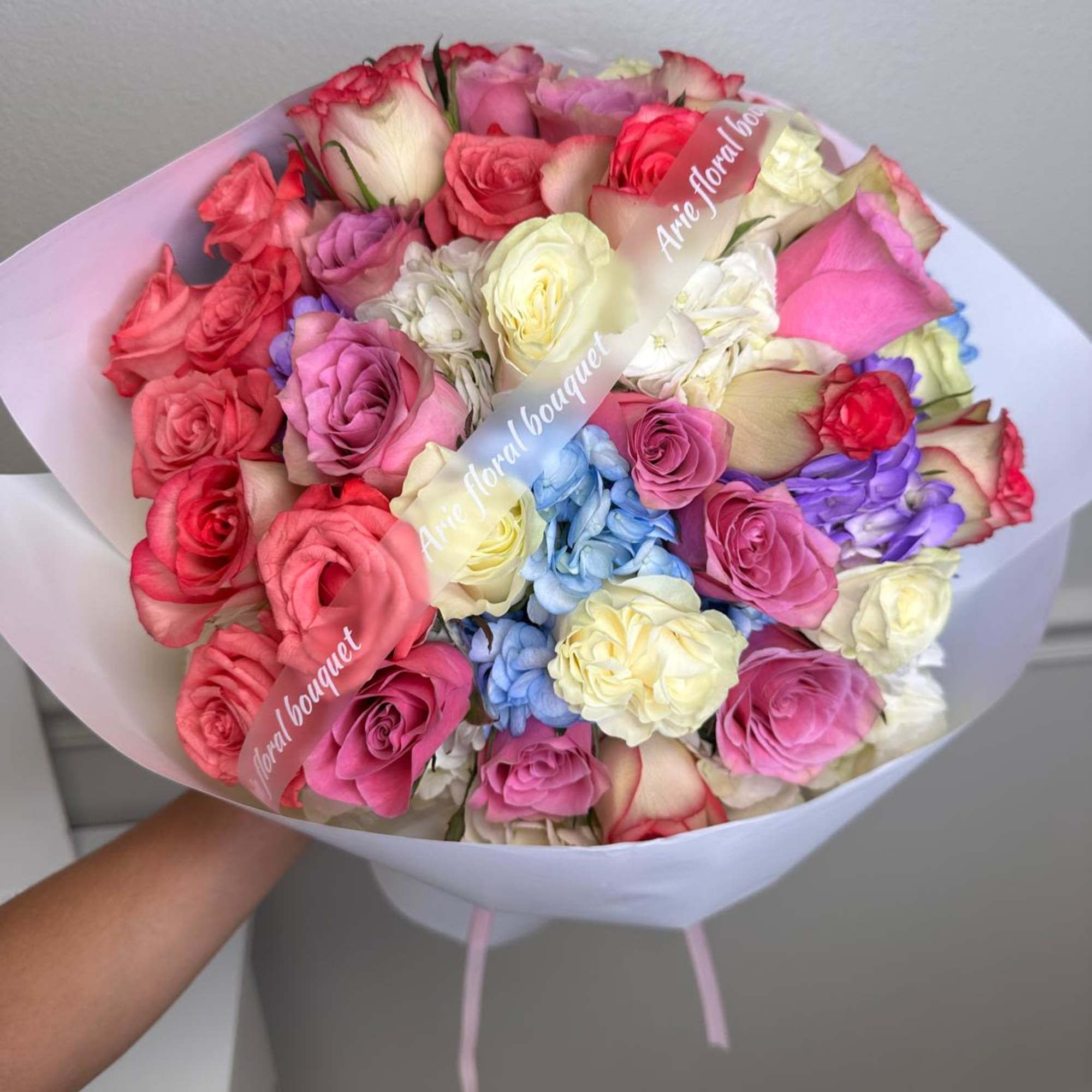 Bouquet of multicolored roses wrapped in white paper, photo 2 of 2