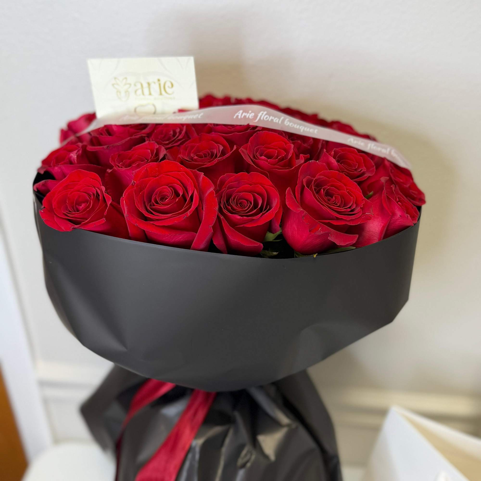 Bouquet of red roses wrapped in black paper