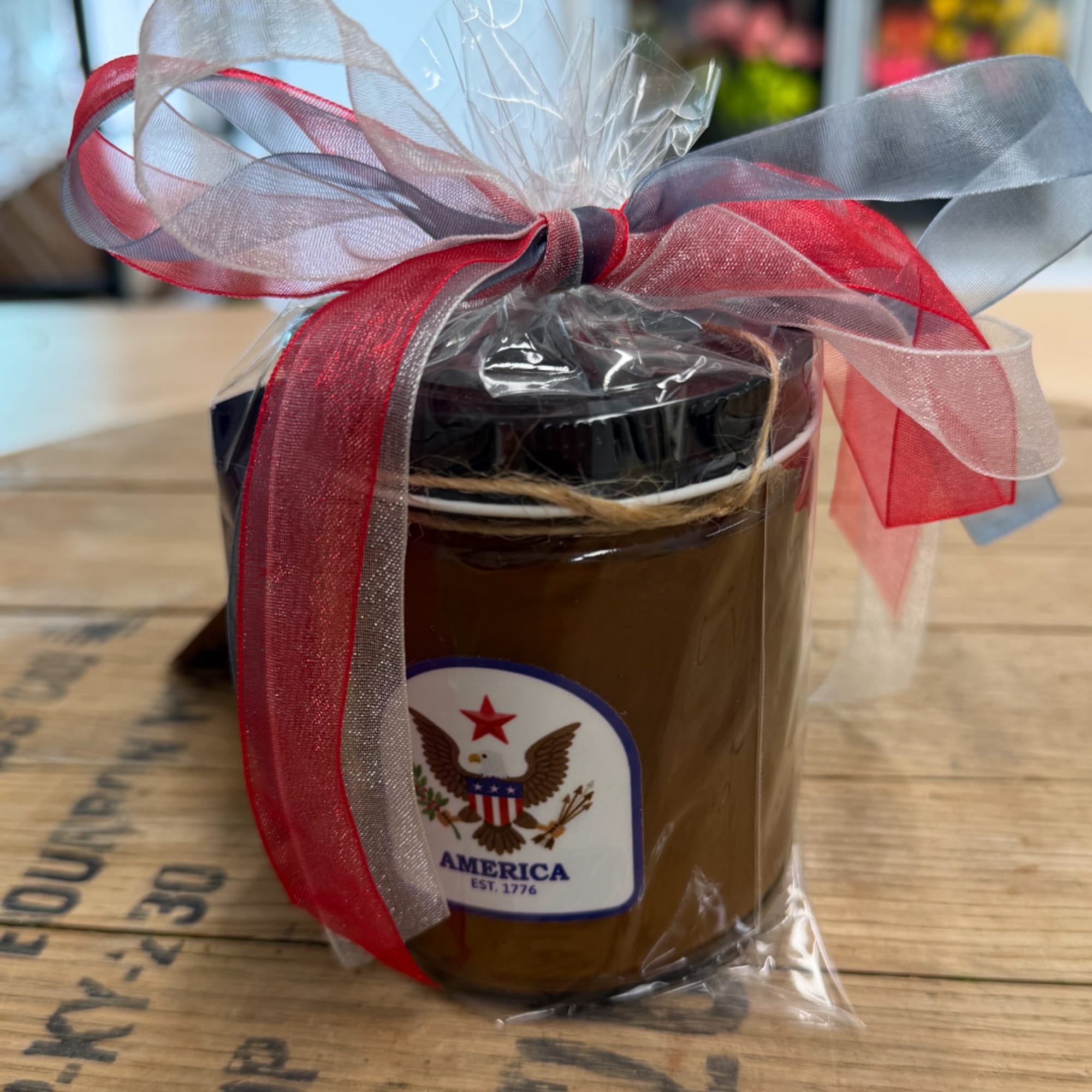 Gift jar wrapped in clear plastic with a red and silver ribbon