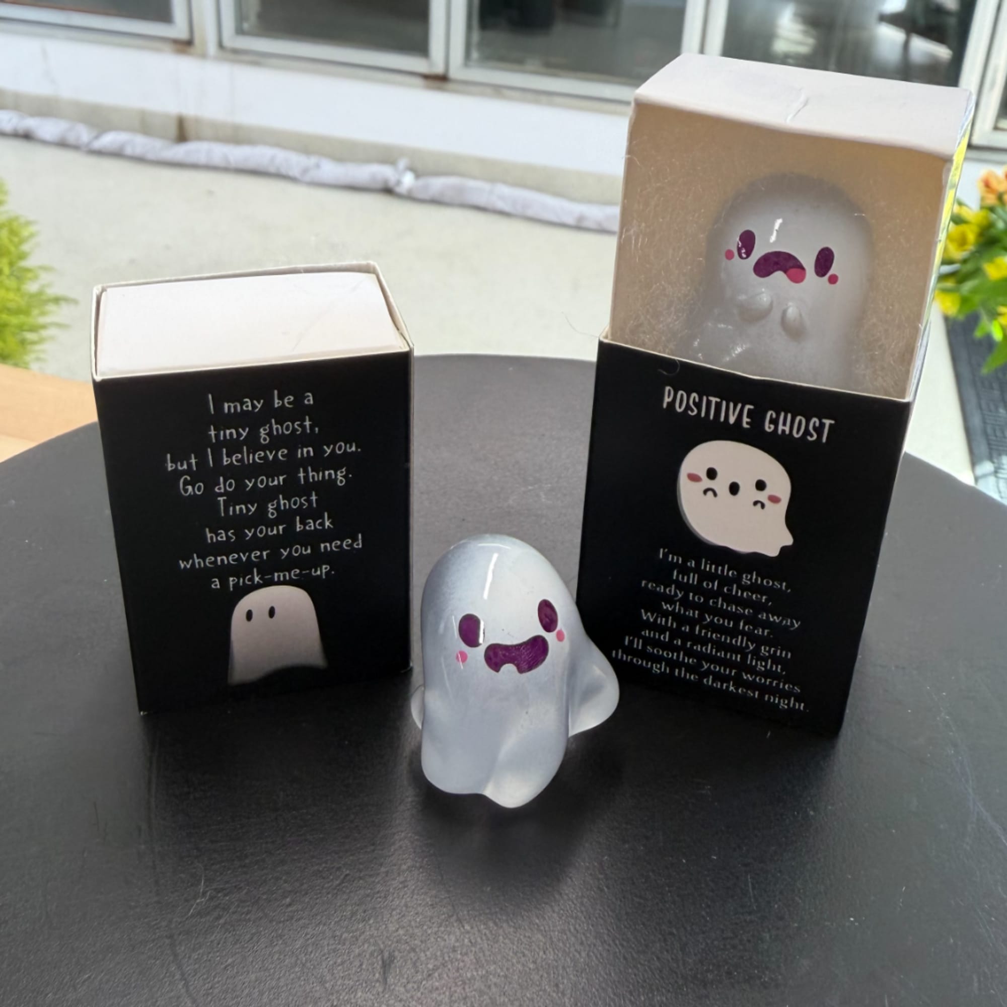 Small ghost figurines in black gift boxes on a table