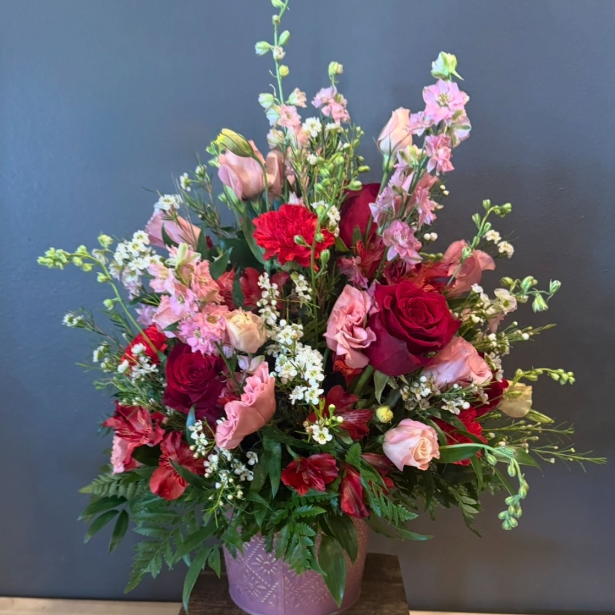 Mixed bouquet of red and pink roses in a pink vase