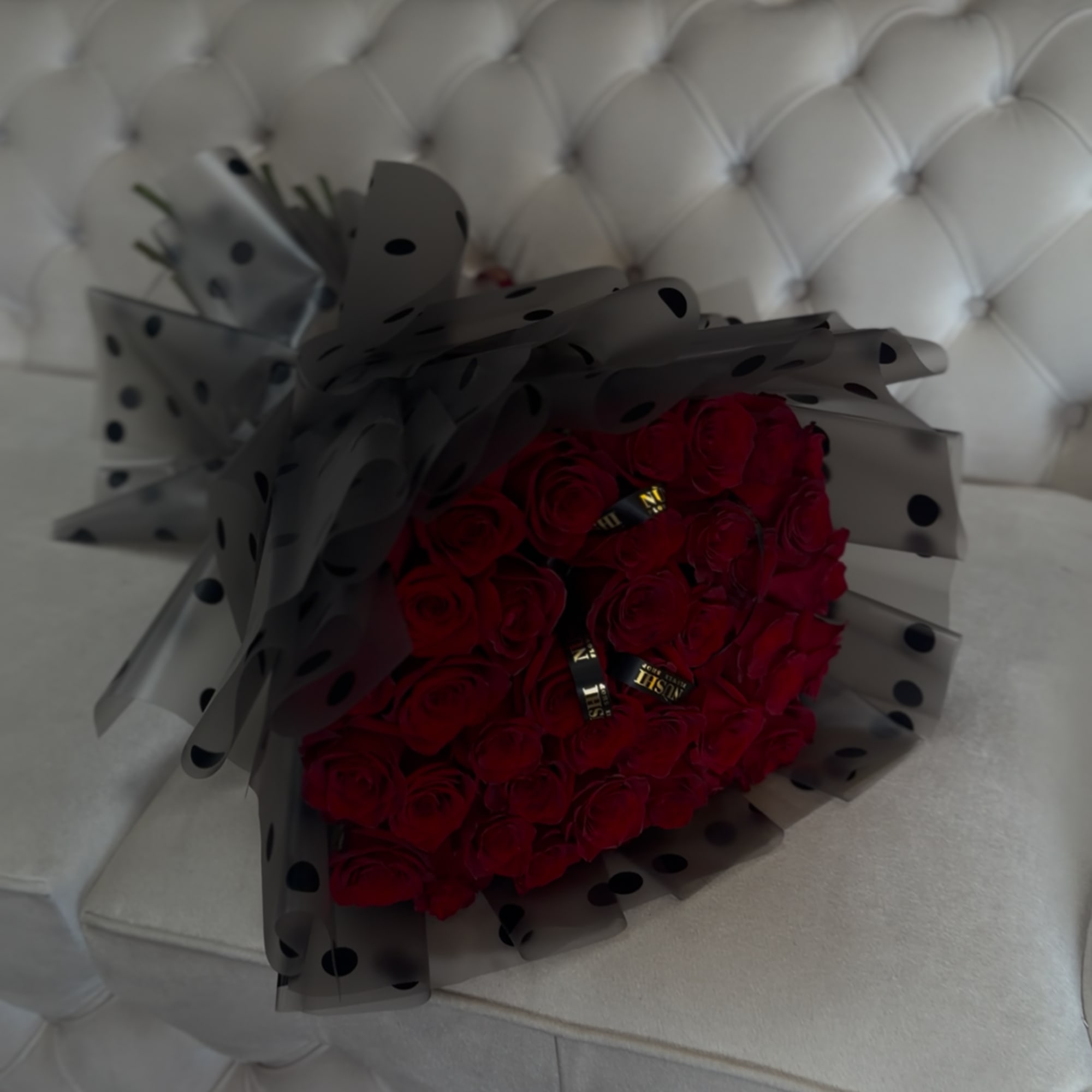 Bouquet of red roses wrapped in black polka-dot paper