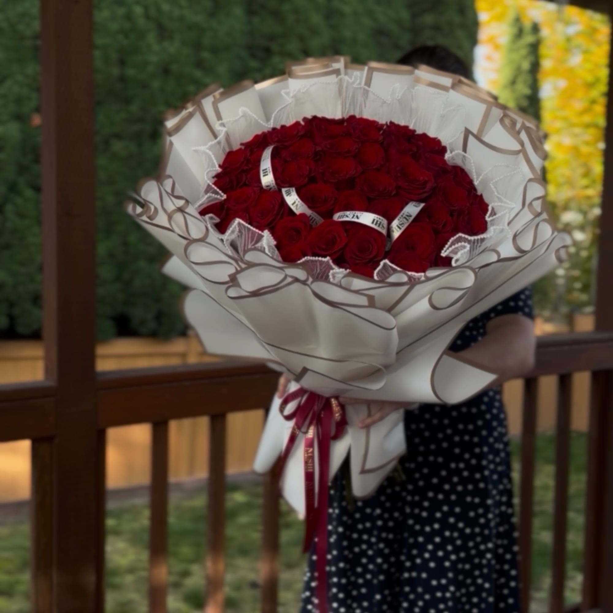 Large bouquet of red roses wrapped in white paper