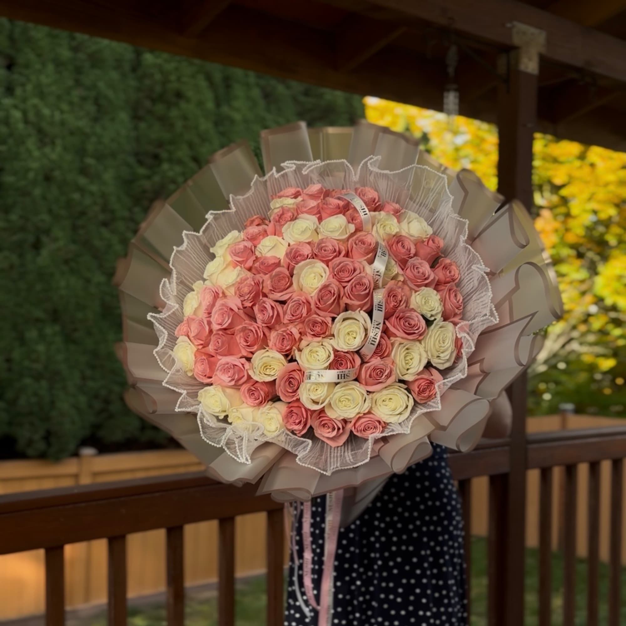 Large bouquet of pink and cream roses wrapped in taupe paper