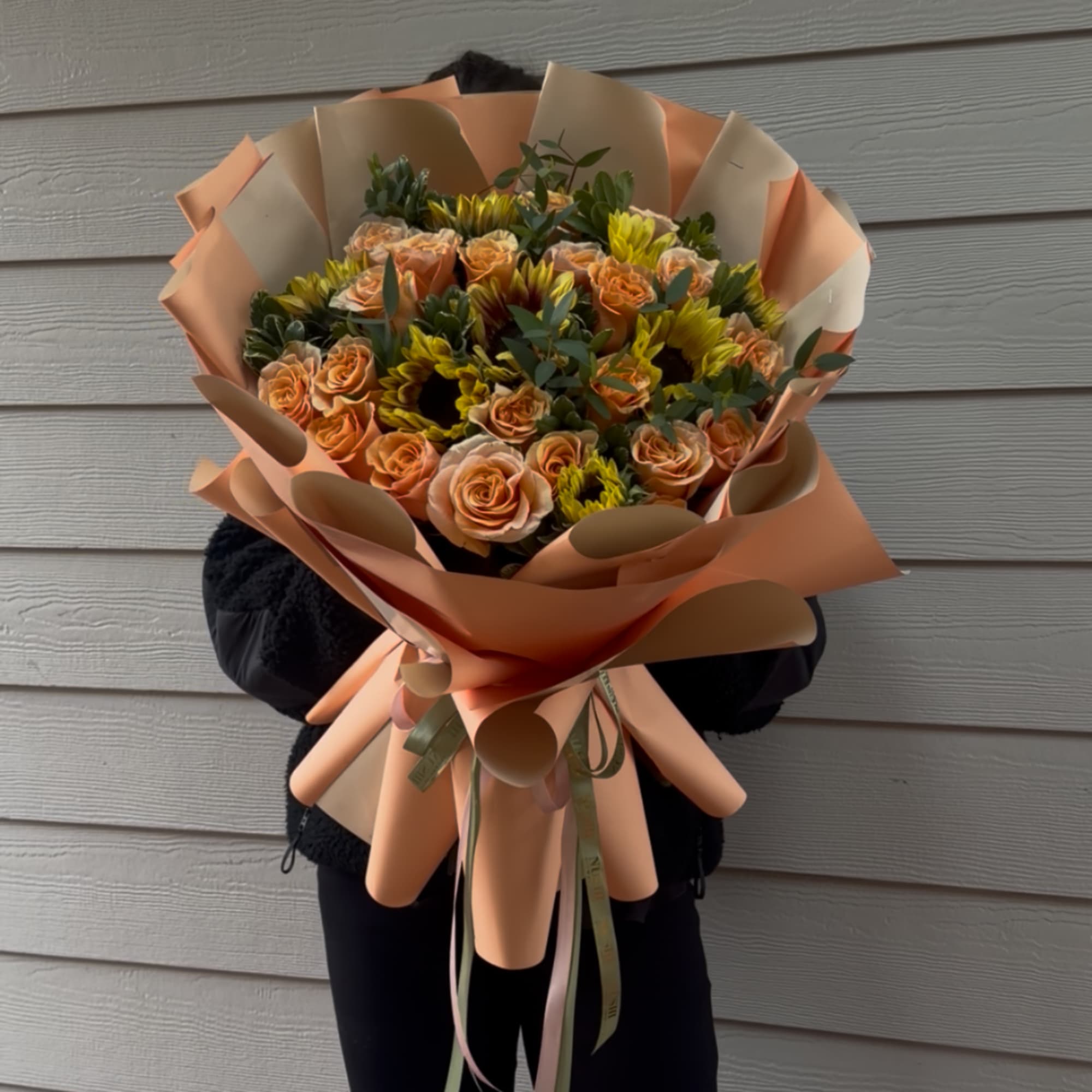 Peach roses and yellow sunflowers wrapped in peach paper