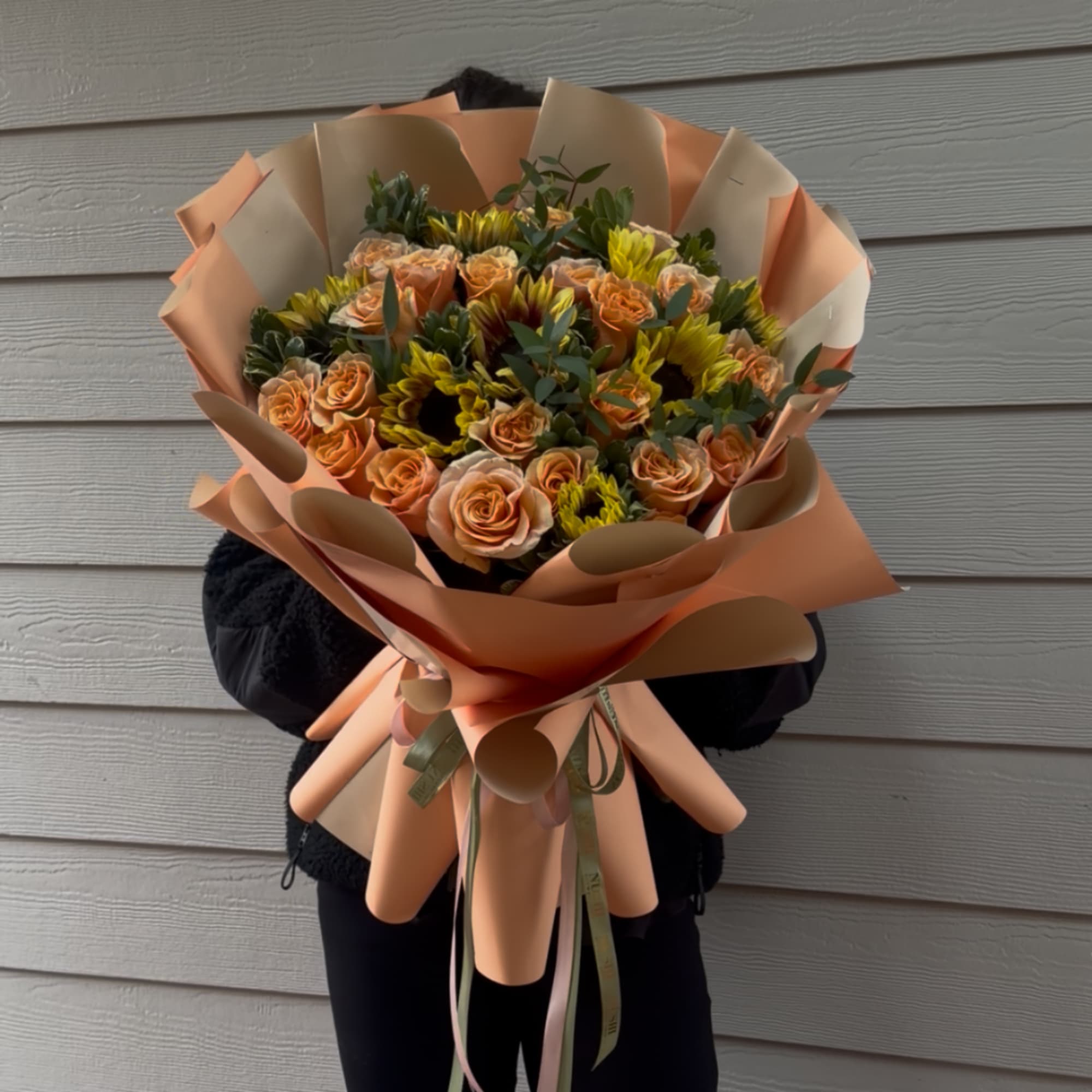 Peach roses and yellow sunflowers wrapped in peach paper
