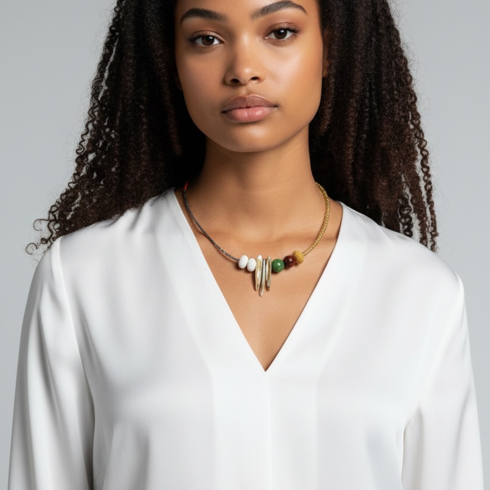 Portrait of a woman wearing a white blouse and beaded necklace