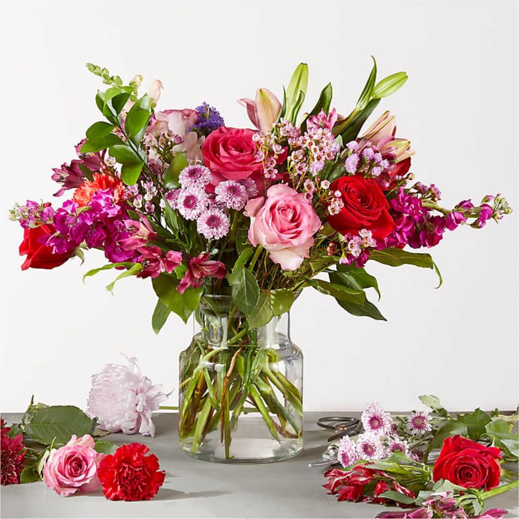 Mixed bouquet of roses and lilies in a clear glass vase
