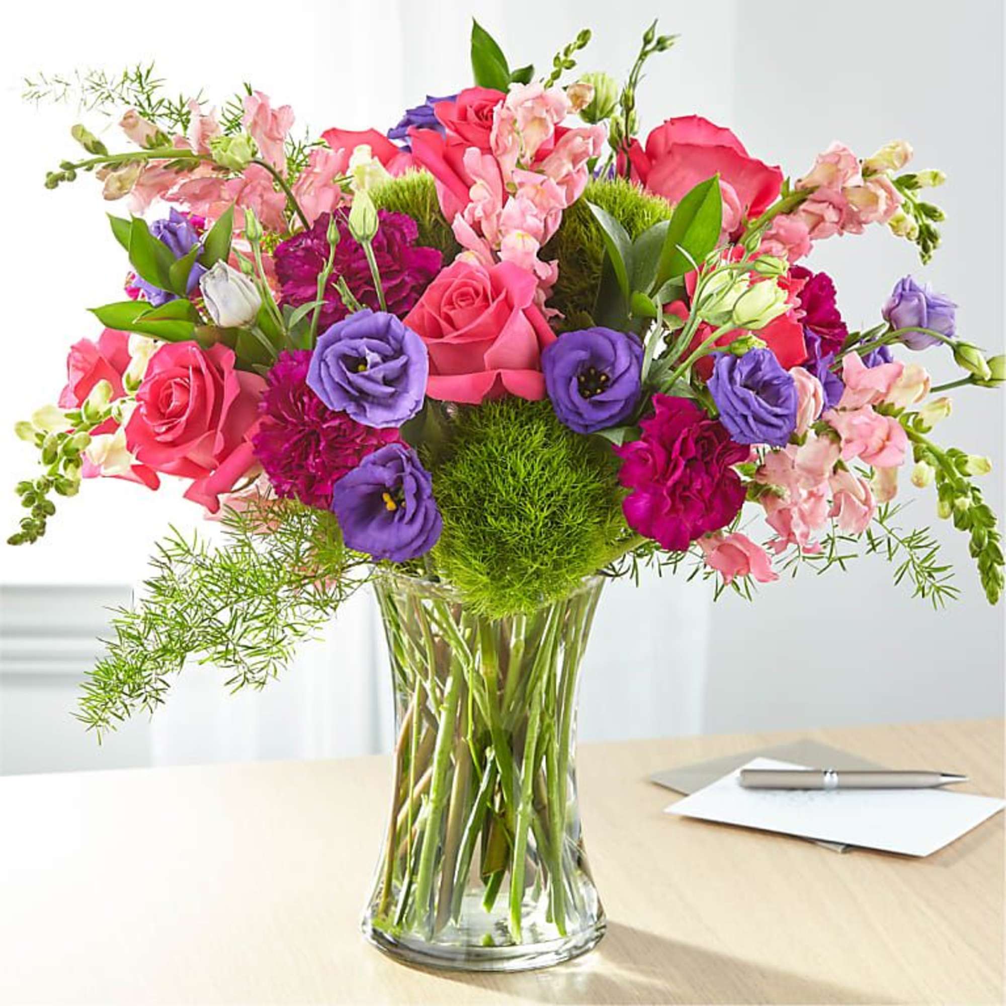 Pink and purple mixed bouquet in a clear glass vase