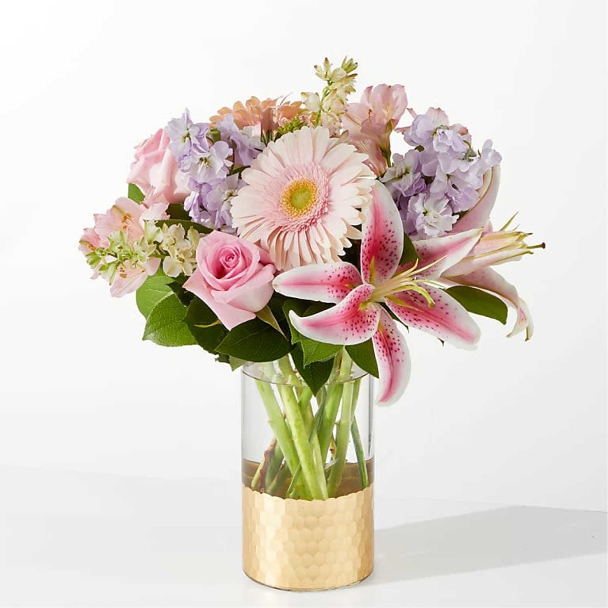 Pink and lavender bouquet in a clear vase with a gold base