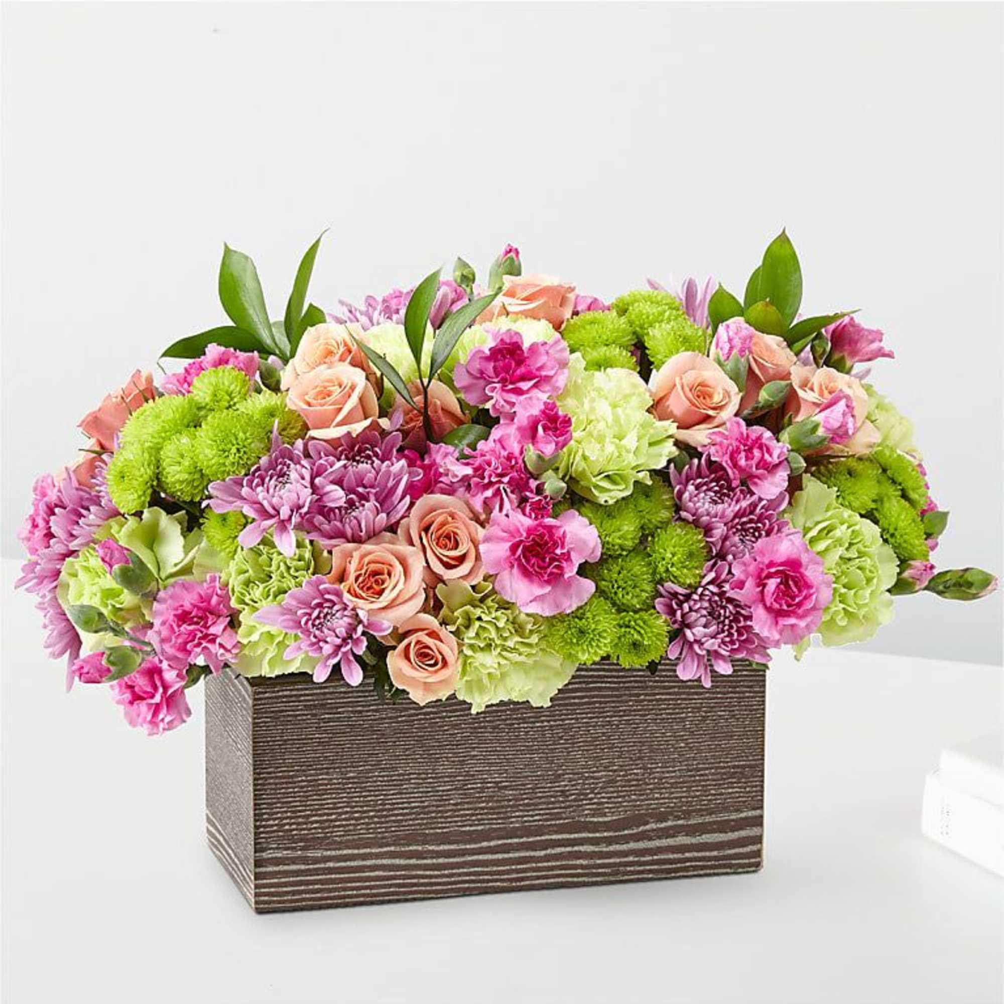 Pink and green mixed flower arrangement in a rectangular wooden box