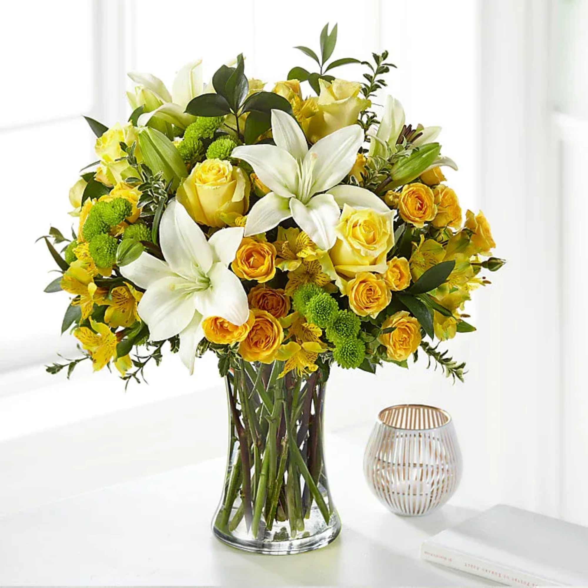 Yellow and white flower arrangement in a clear glass vase