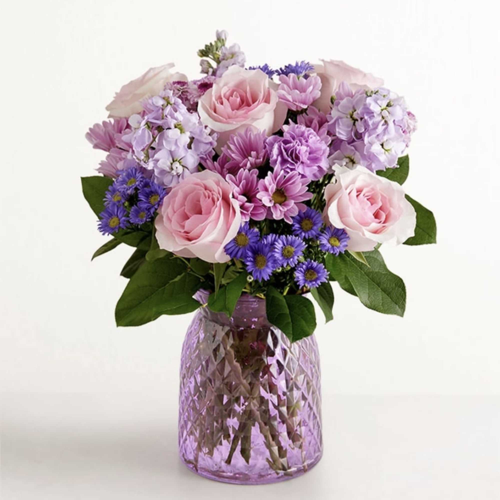 Pink roses and purple daisies in a textured lavender vase
