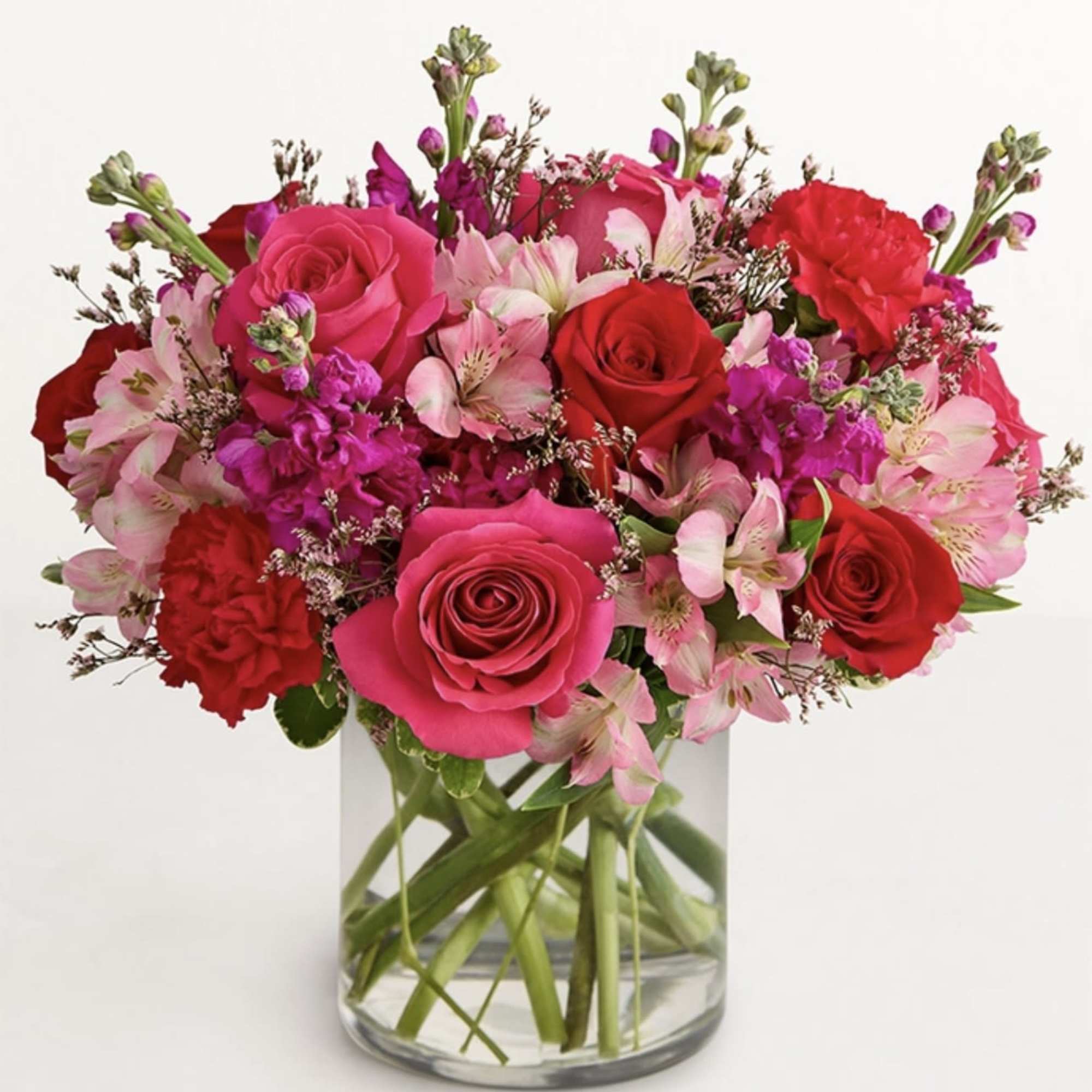 Pink and red roses with alstroemeria in a clear glass vase