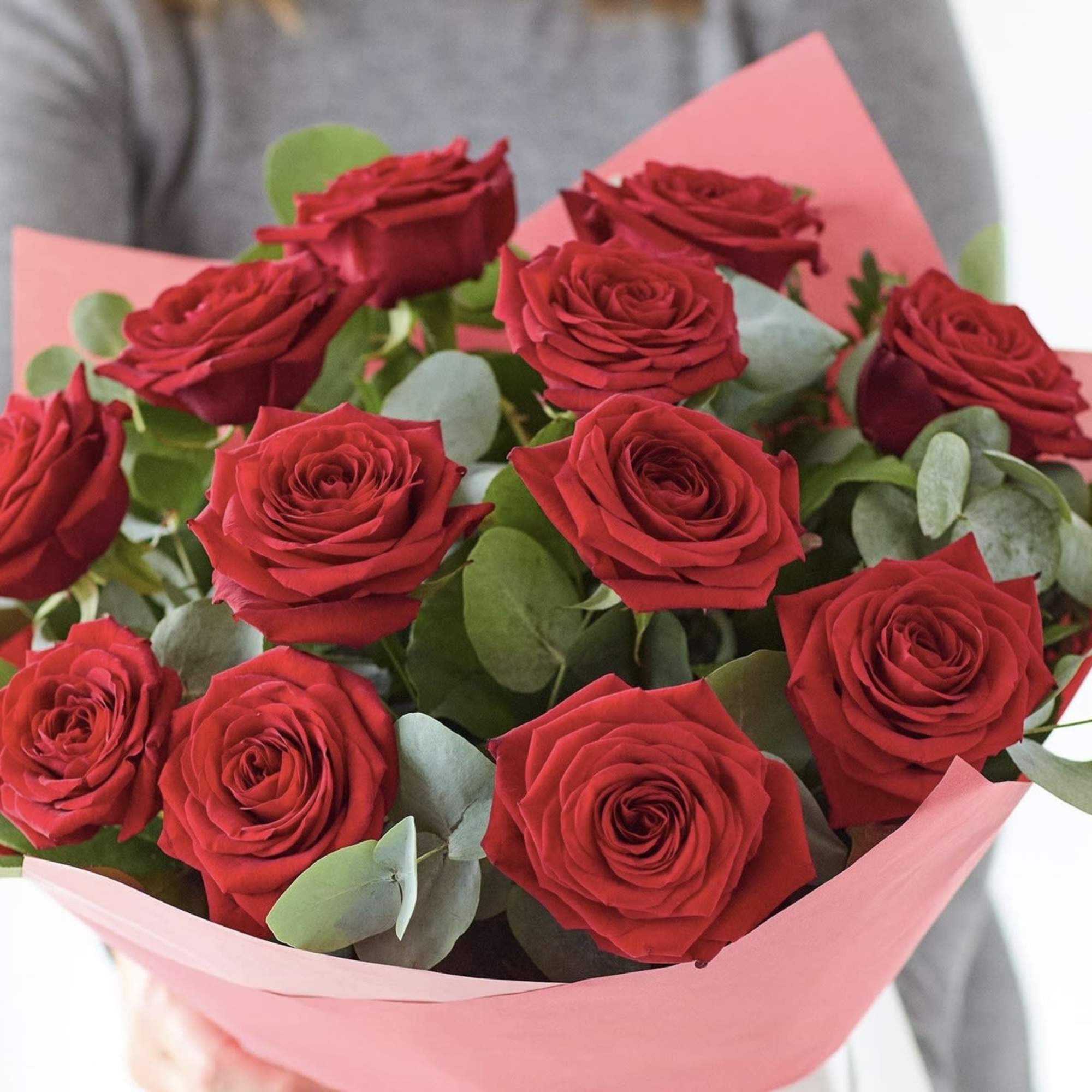 Bouquet of red roses wrapped in pink paper