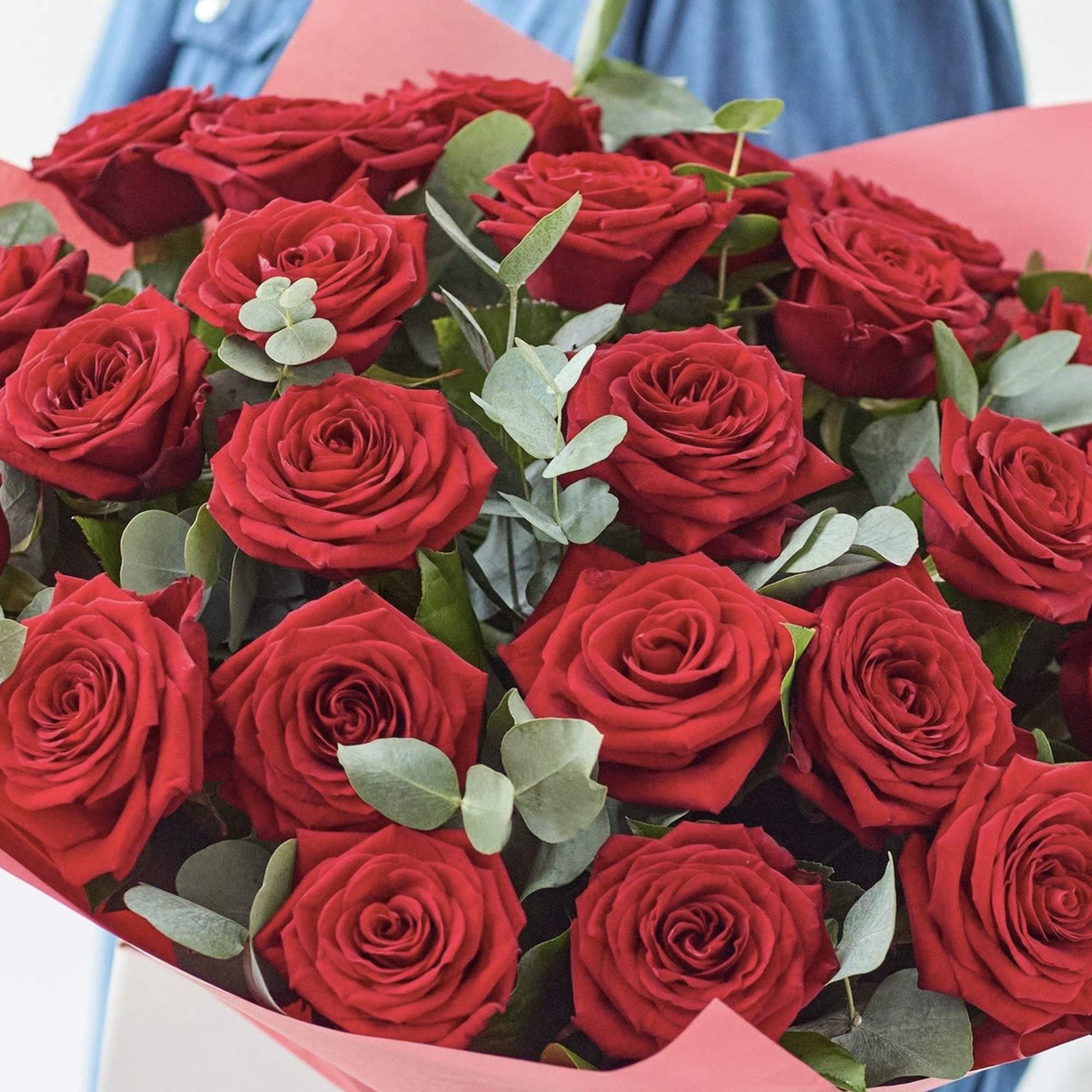 Bouquet of red roses with eucalyptus in pink wrapping