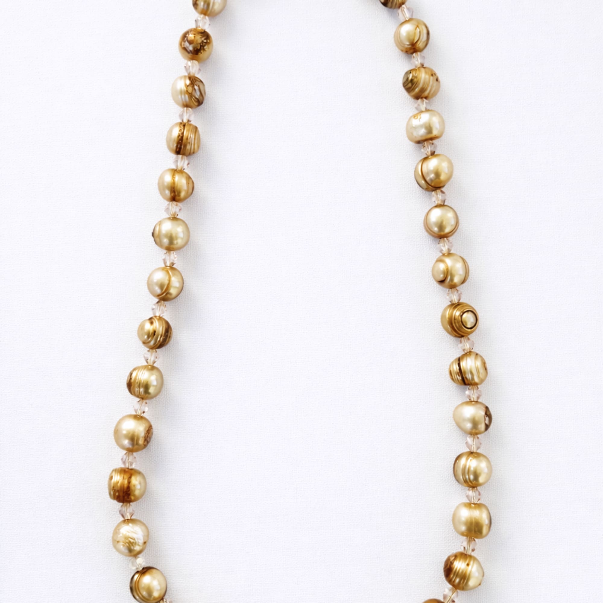 Gold beaded necklace on a white background